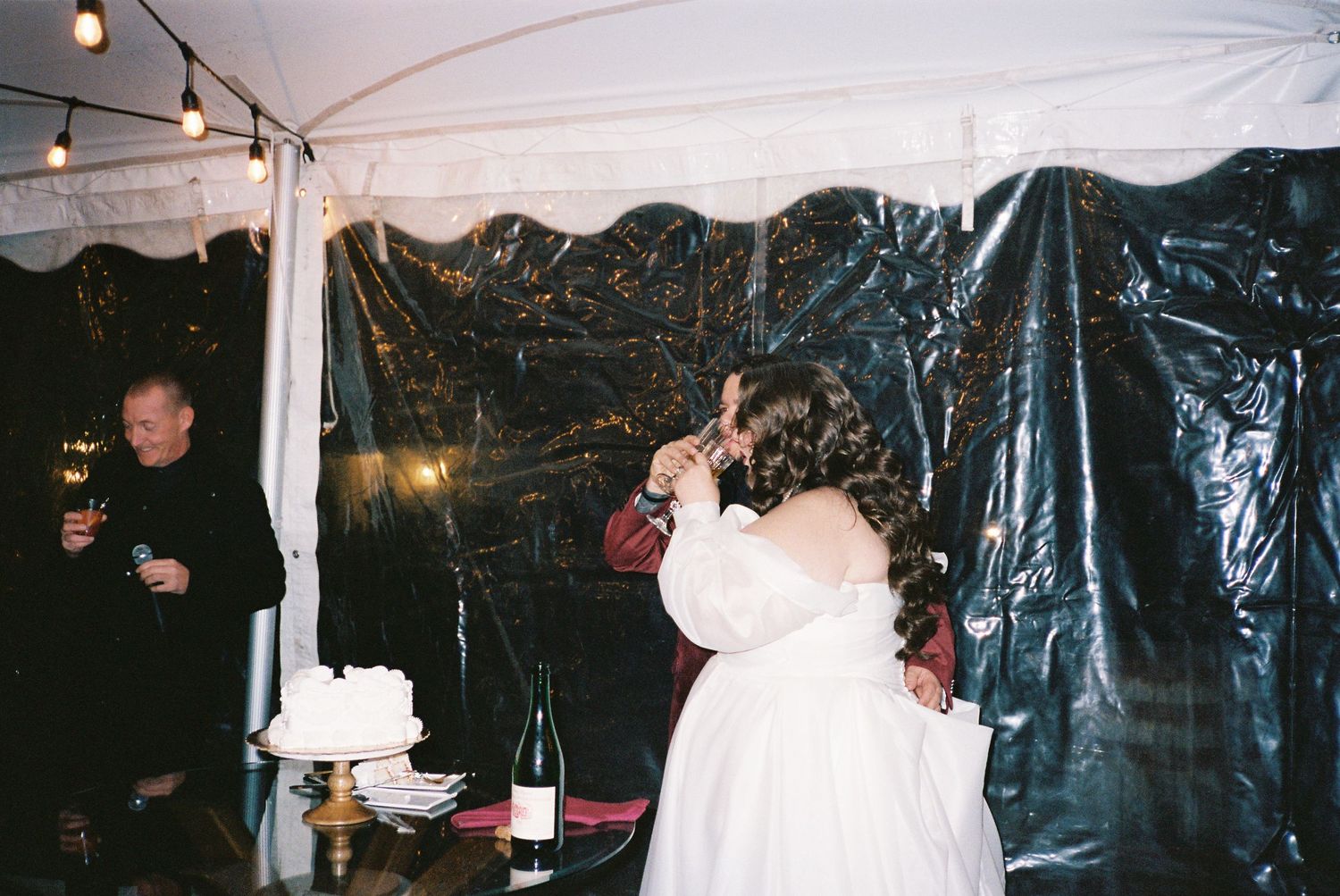 Wedding reception venue decorated with ambient lighting and dark draping.