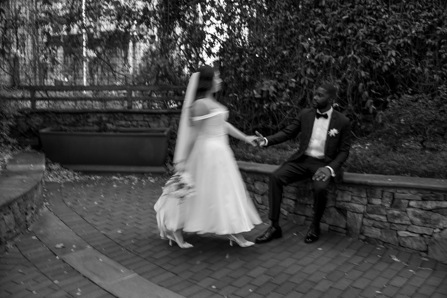Wedding celebration in a garden setting with guests dancing on brick patio.