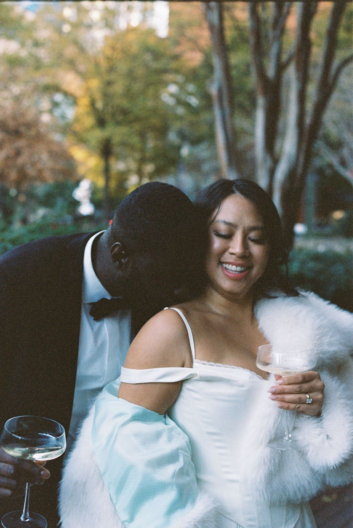 A couple sharing an intimate moment during their wedding reception while wearing formal attire.