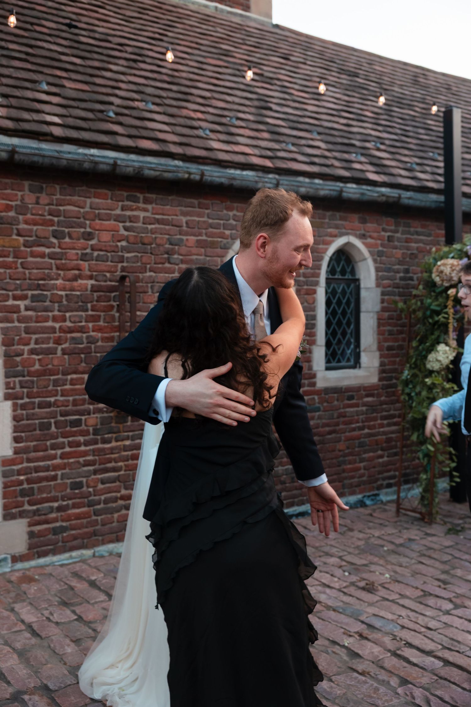 Sequence of romantic dance dips on a brick patio under string lights at dusk.