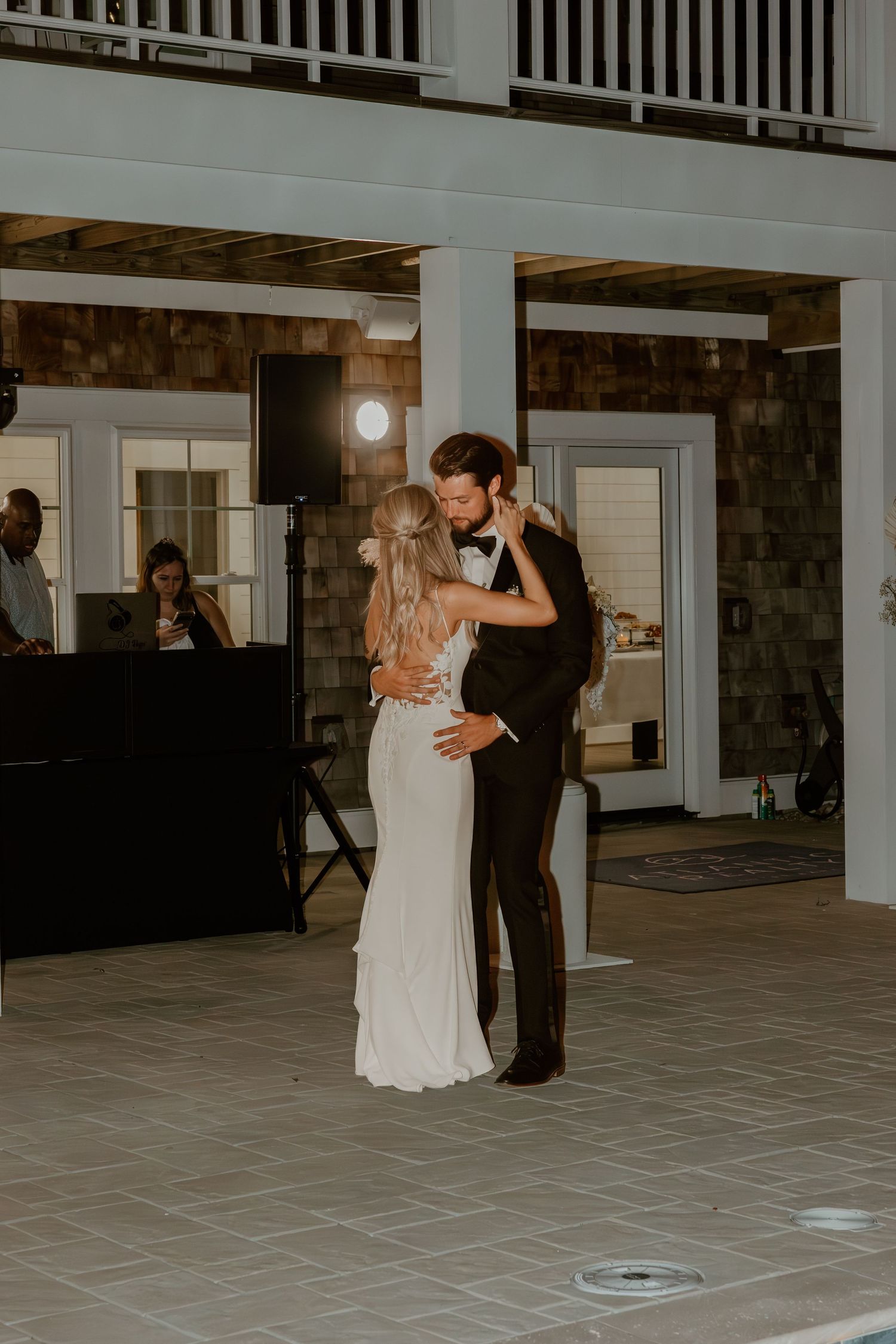 A couple shares a romantic first dance together at their wedding reception in a spacious venue.
