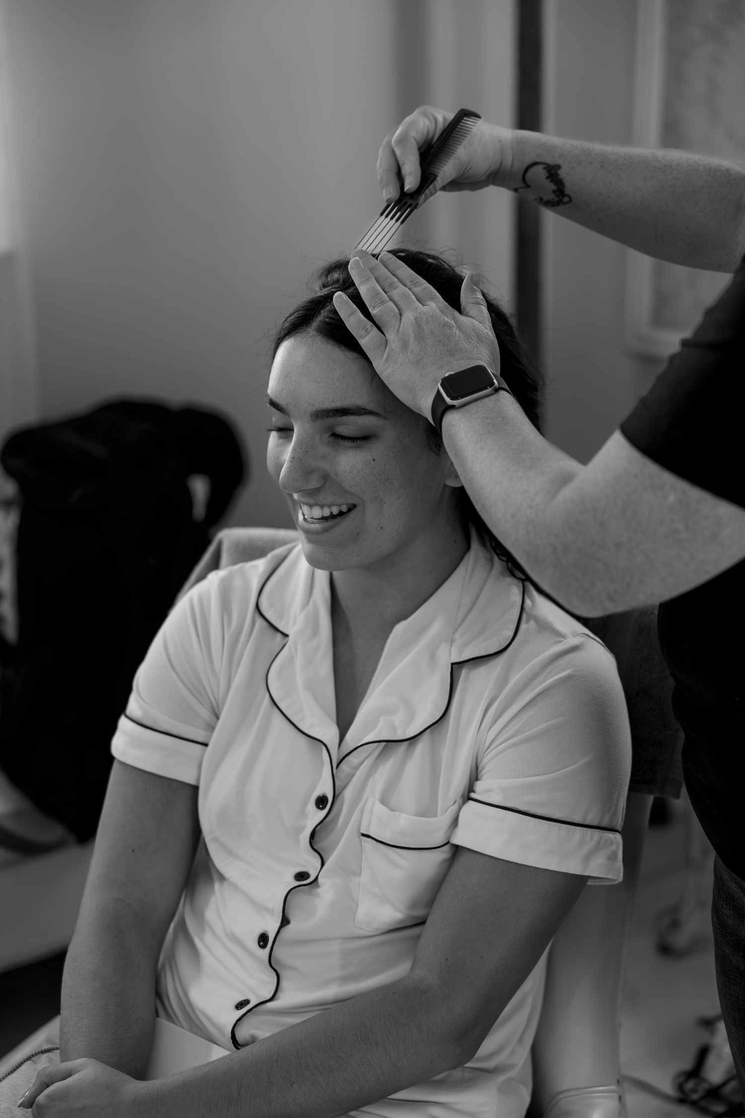 Intimate getting ready moment captured in black and white photography.