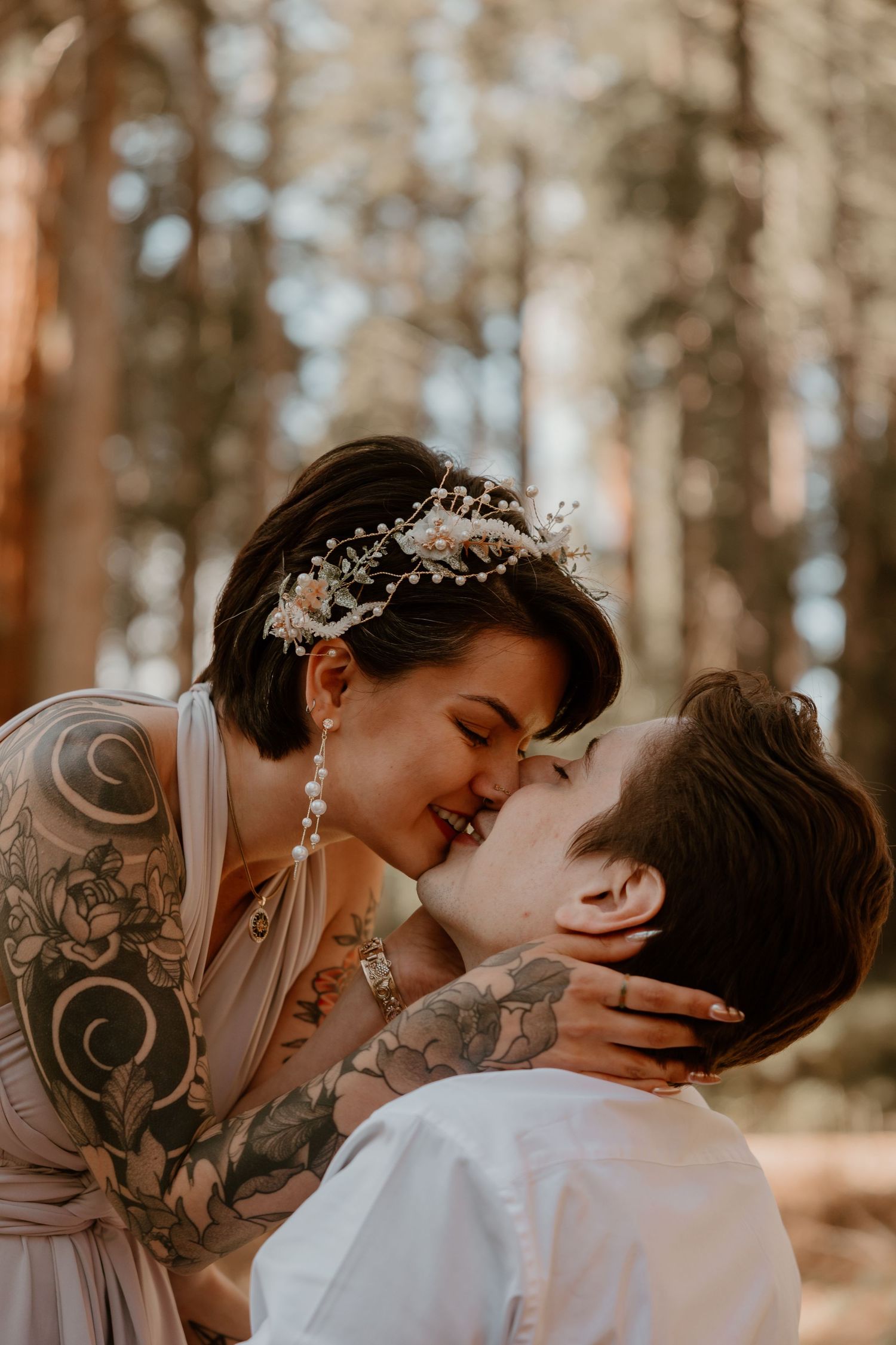 An intimate moment between newlyweds in a sunlit forest setting.