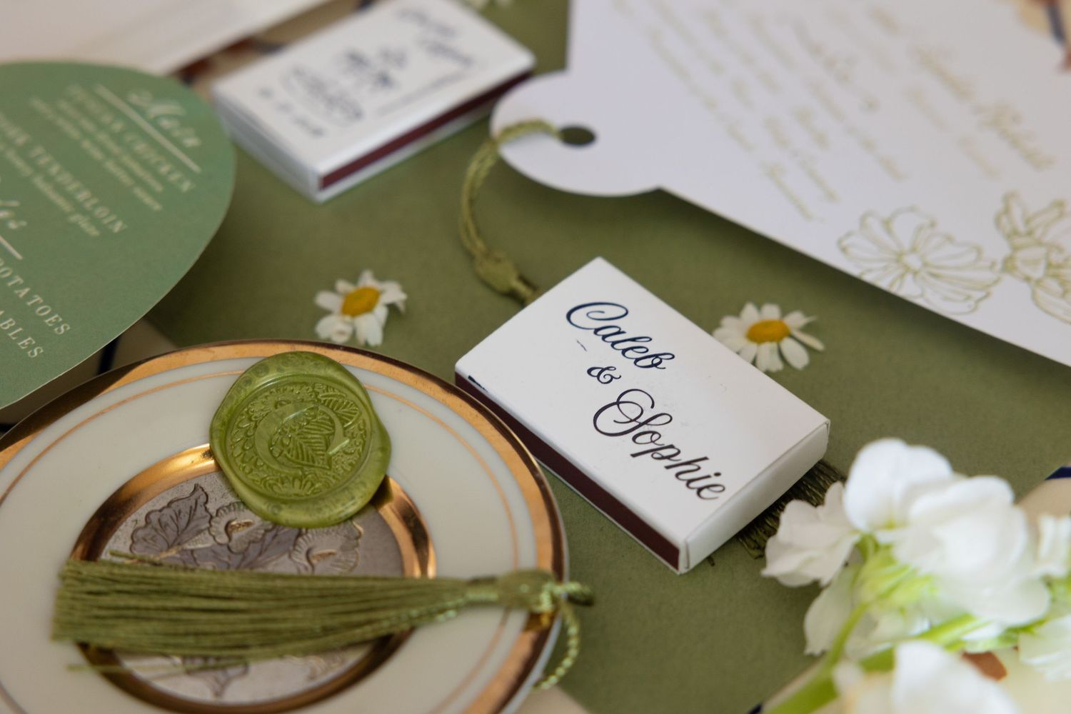 Elegant wedding stationery and invitations in sage green and white with delicate floral accents and wax seals.