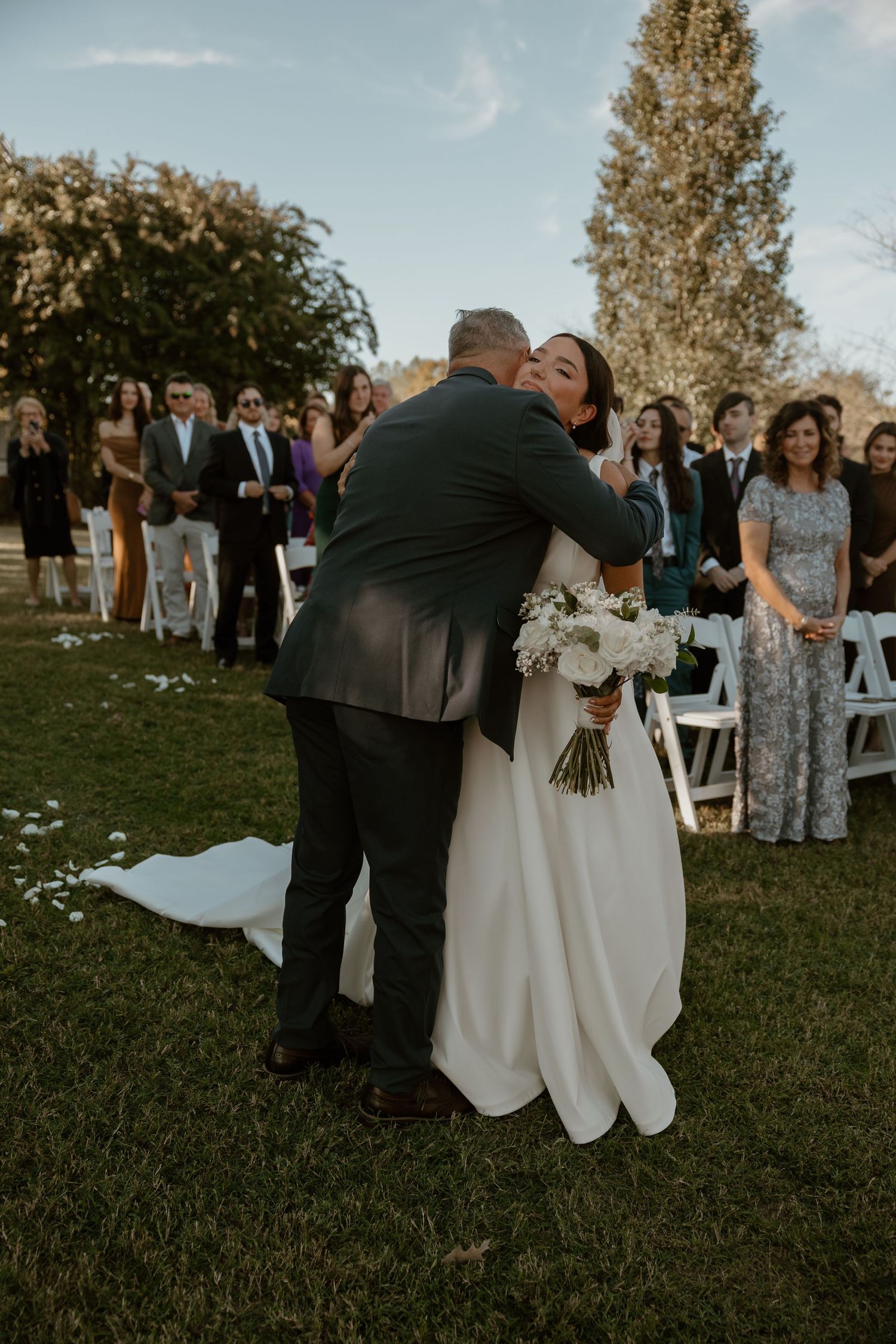 A tender moment captured during a first dance at an outdoor wedding reception.