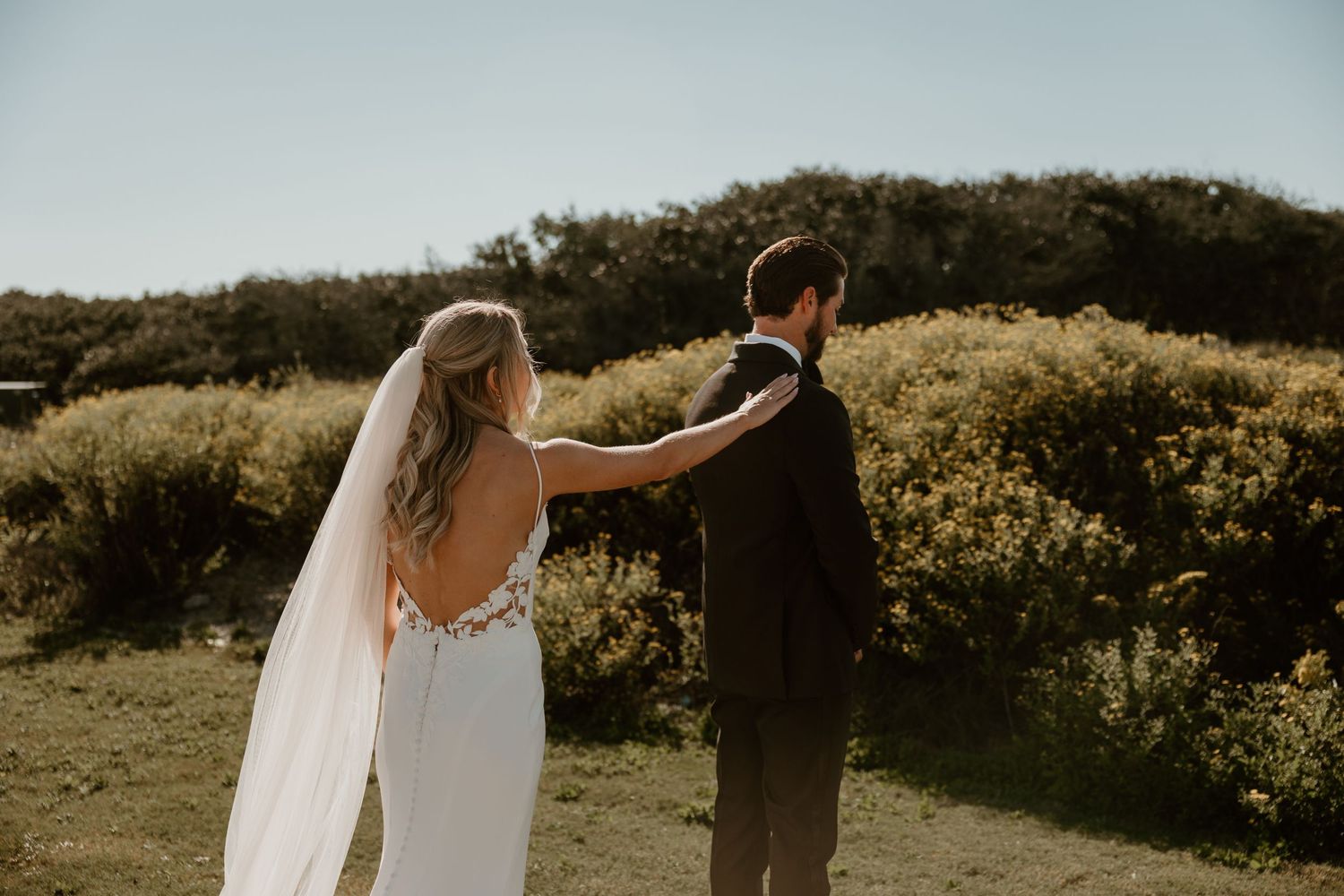 Couple sharing first look moment during outdoor coastal wedding ceremony.