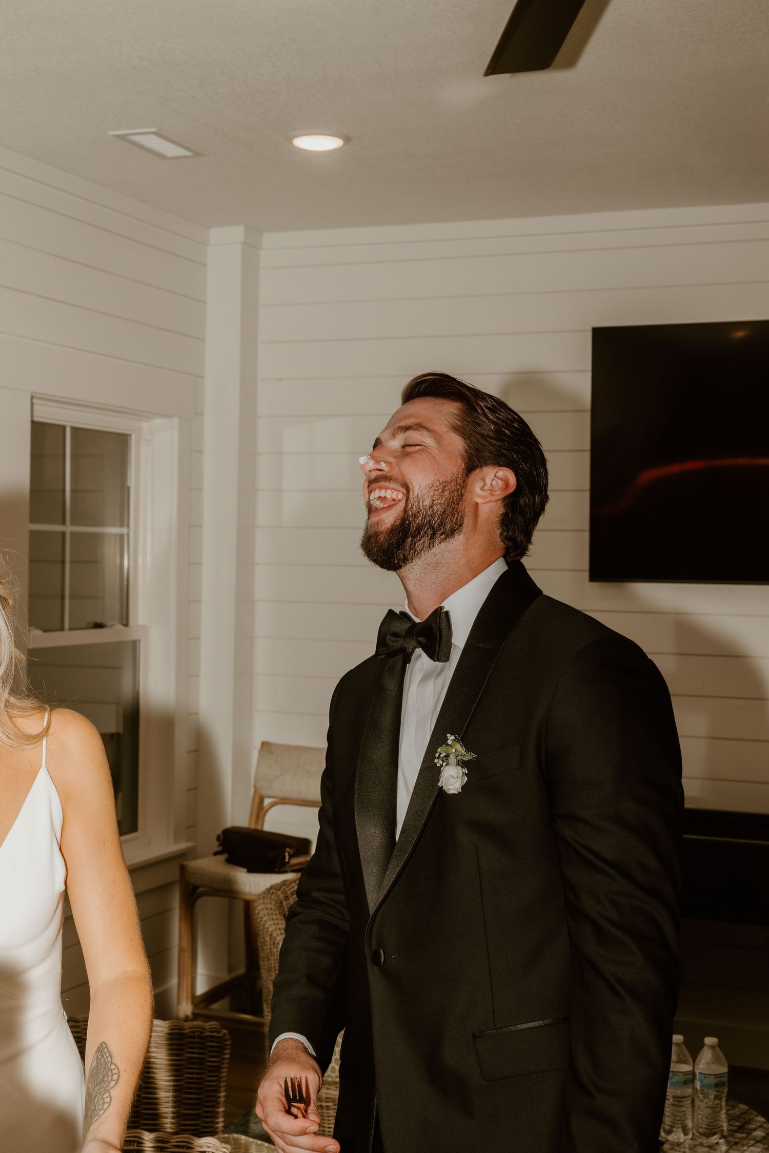 Candid laughter and joy captured during a wedding cake tasting moment.