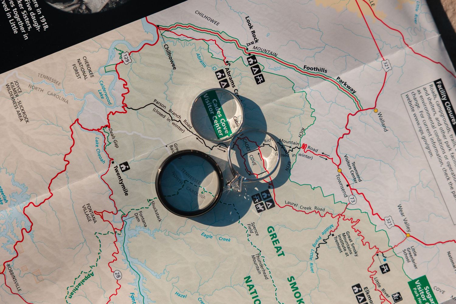 Two turquoise rings rest on top of a paper map showing red and blue trail routes.