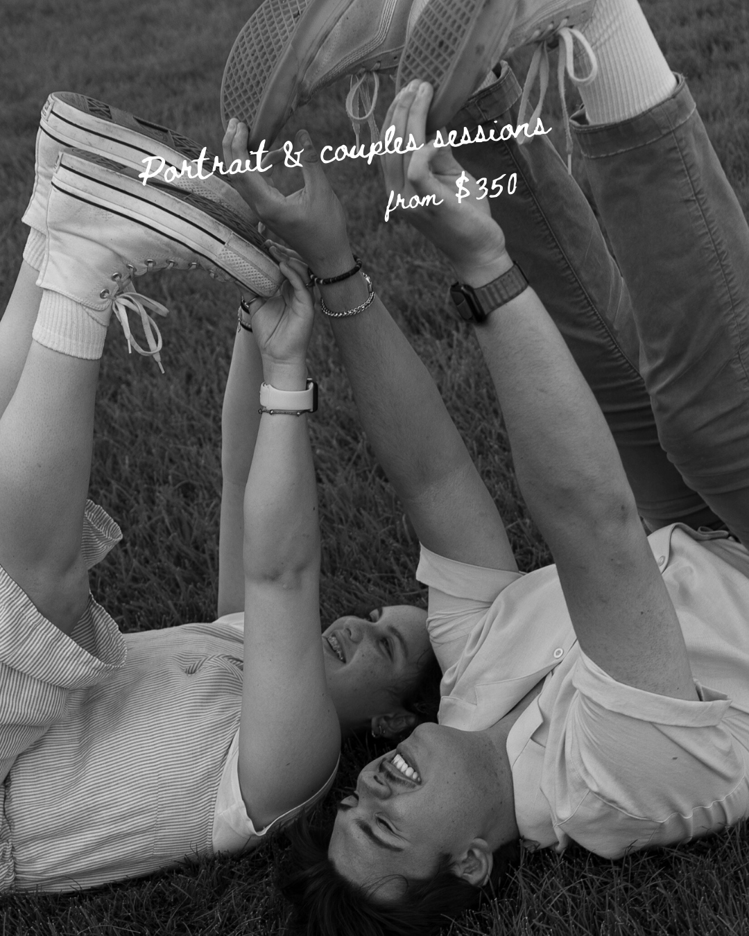 An artistic black and white portrait of a couple lying on grass showing authentic joy.