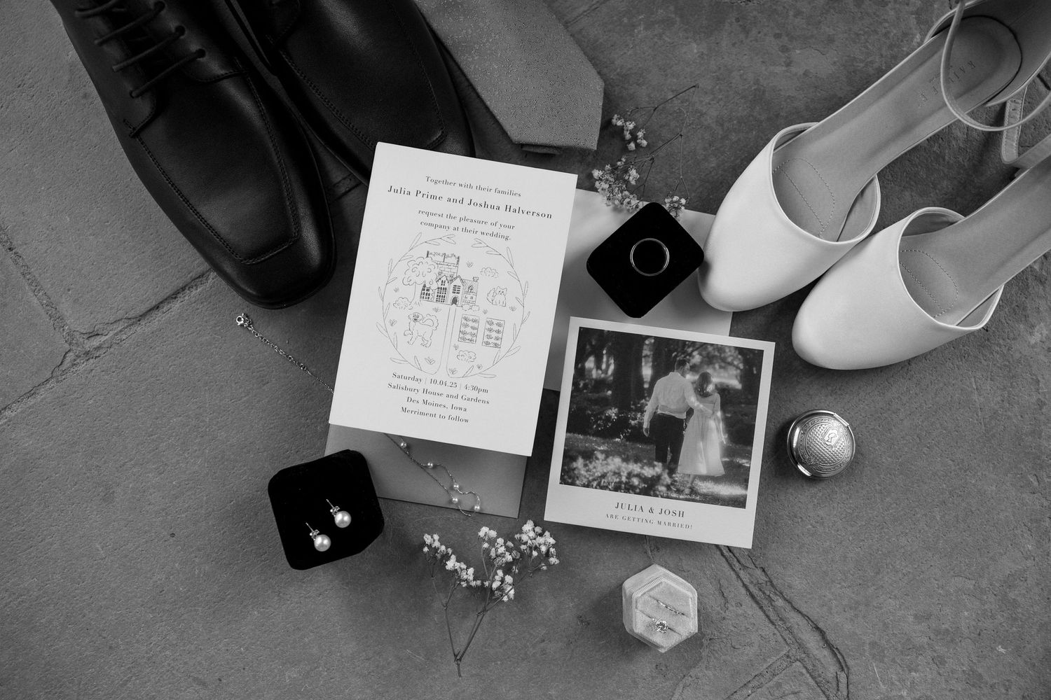 Black and white wedding shoes arranged on a concrete floor with various personal items and photographs scattered around.