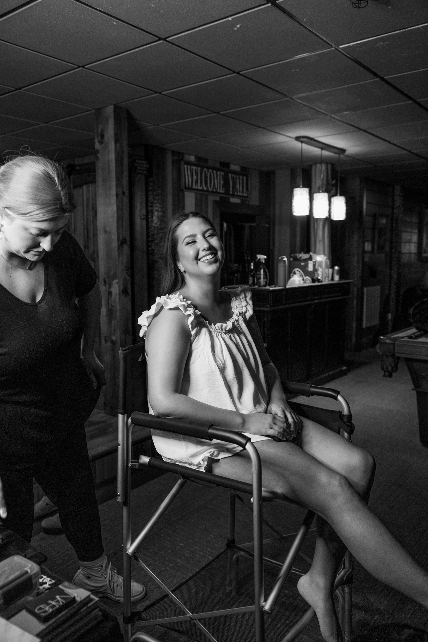 Black and white photo series showing a bride getting ready in a director's chair.