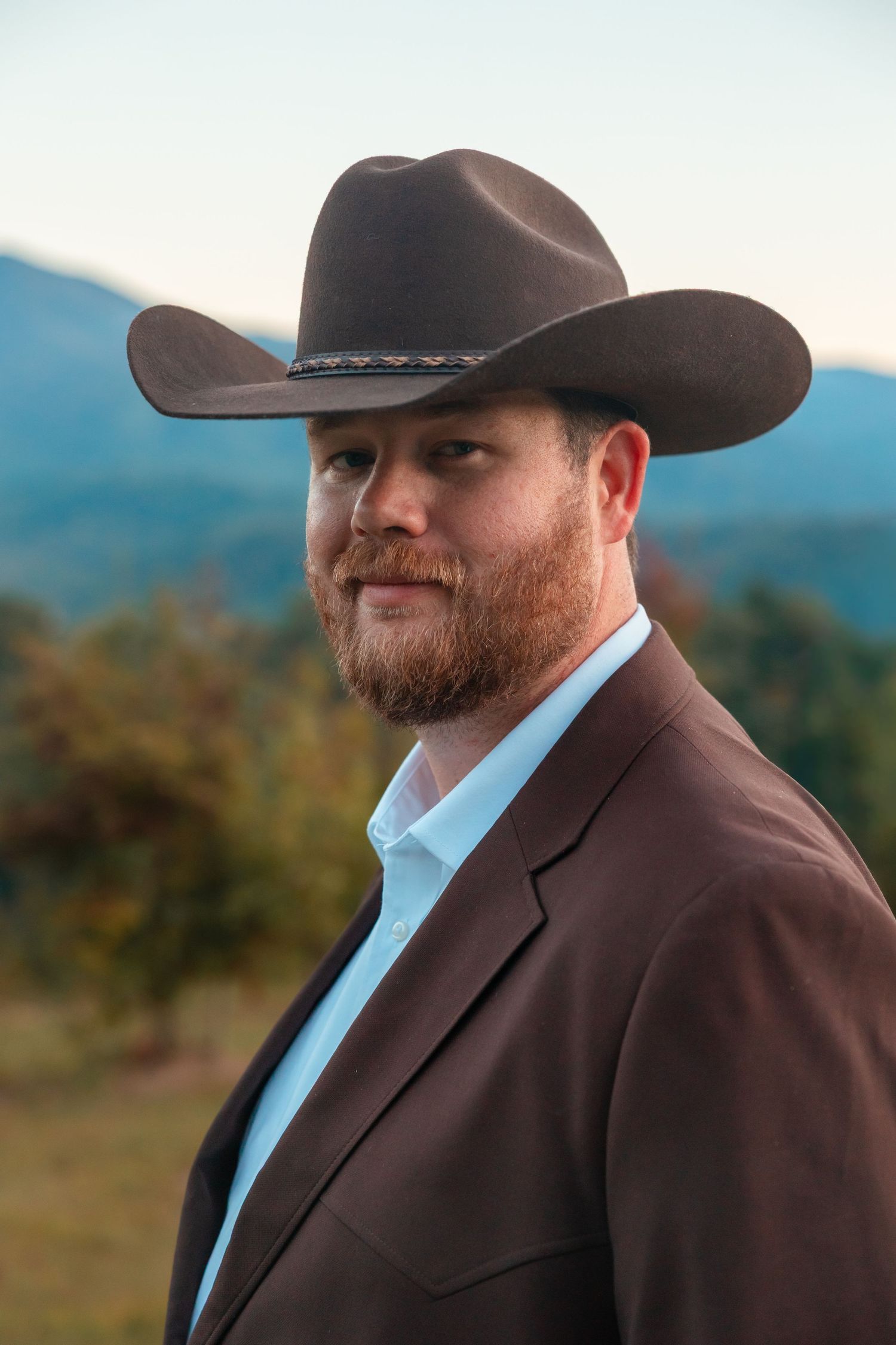 Series of close-up shots showing a groom in a brown suit and cowboy hat against mountain backdrop.