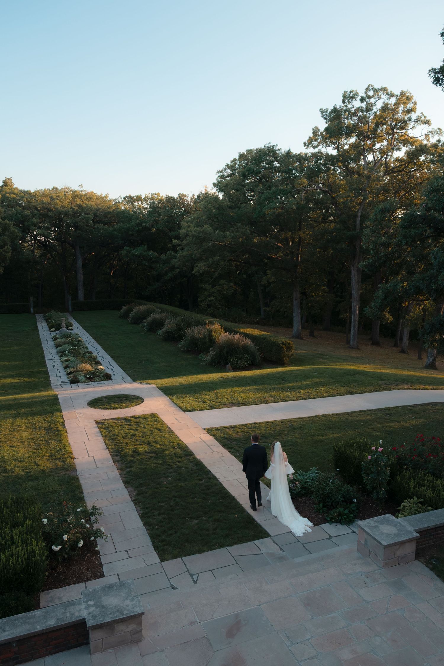 Aerial view of stone pathways intersecting through a park at sunset.