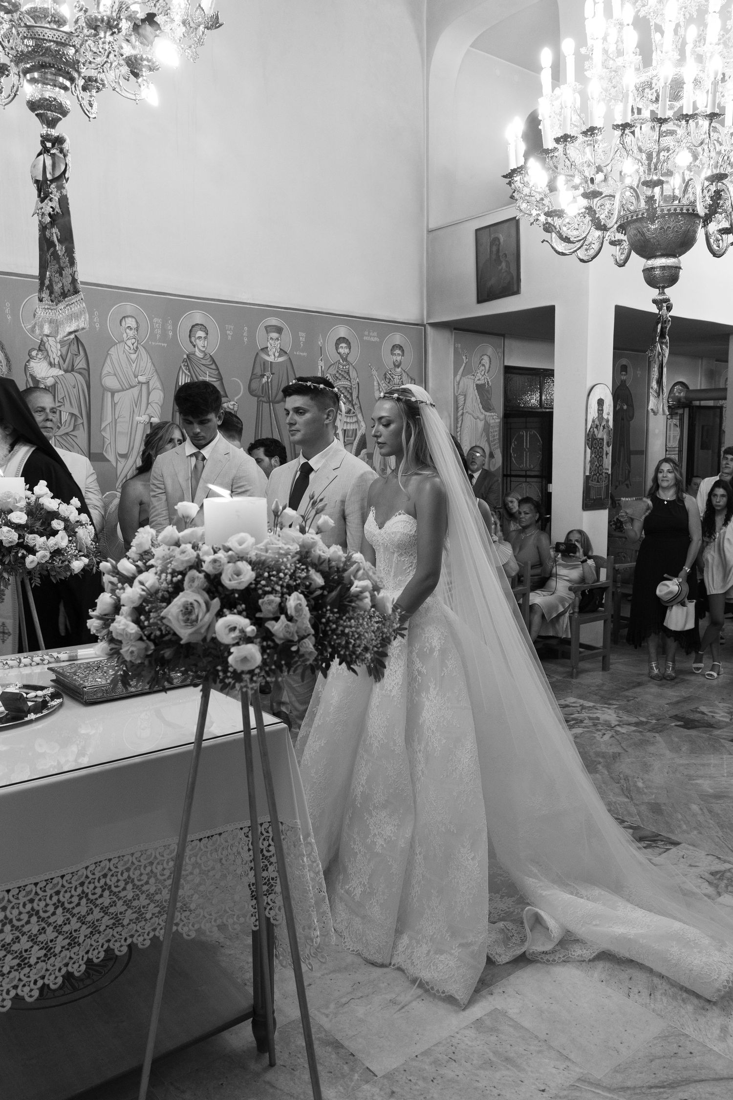An elegant wedding venue with crystal chandeliers and floral arrangements showcasing a bridal preparation scene.