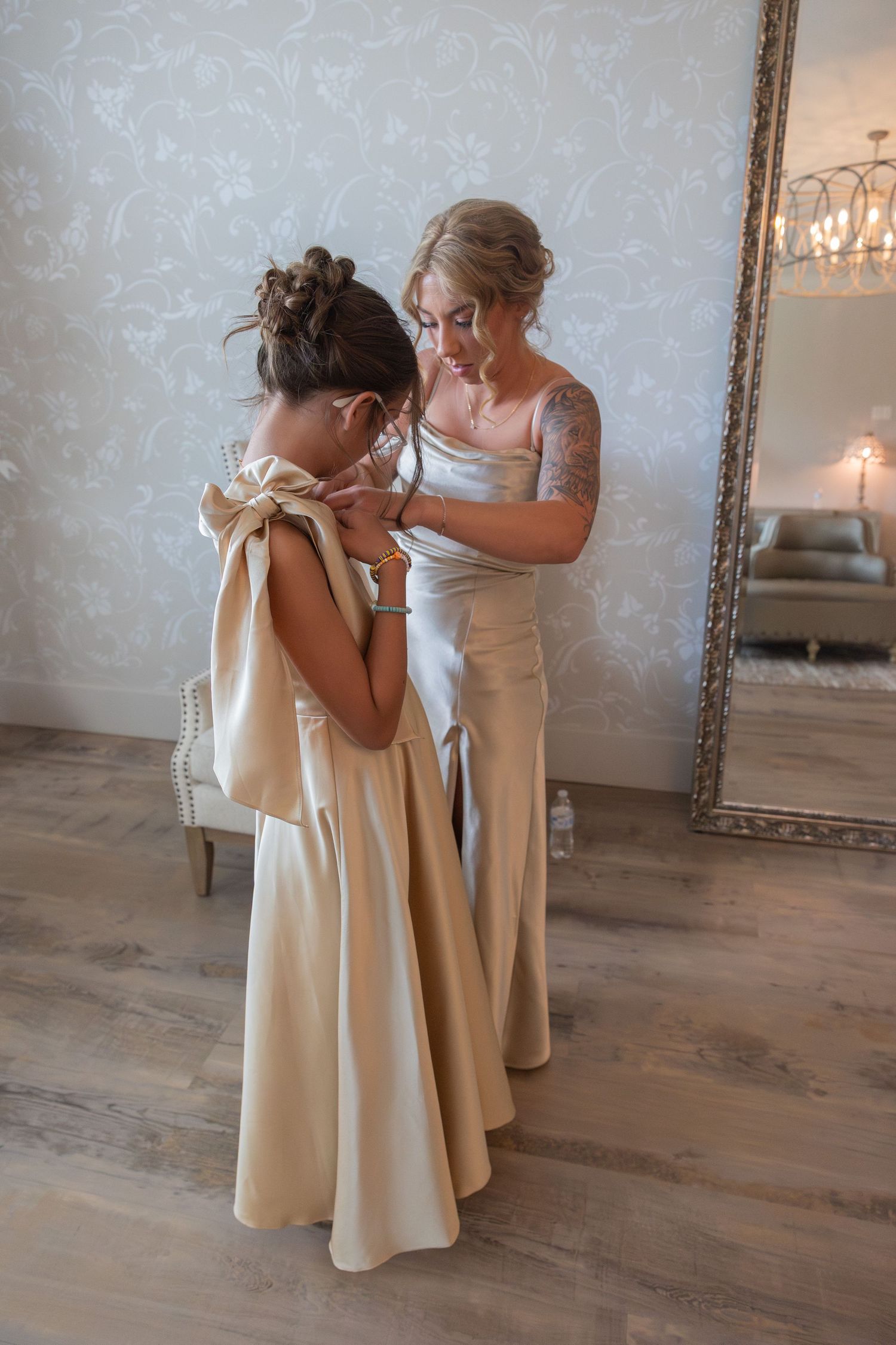 An emotional first look between a mother and daughter in matching cream-colored dresses.