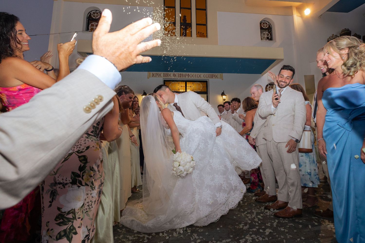 Wedding guests dance and celebrate on a reception dance floor while a bride in white dress twirls in the center.