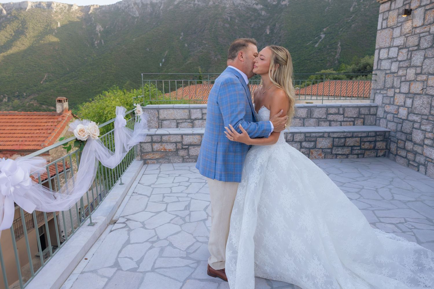 Wedding celebration on a stone terrace overlooking dramatic mountain scenery.