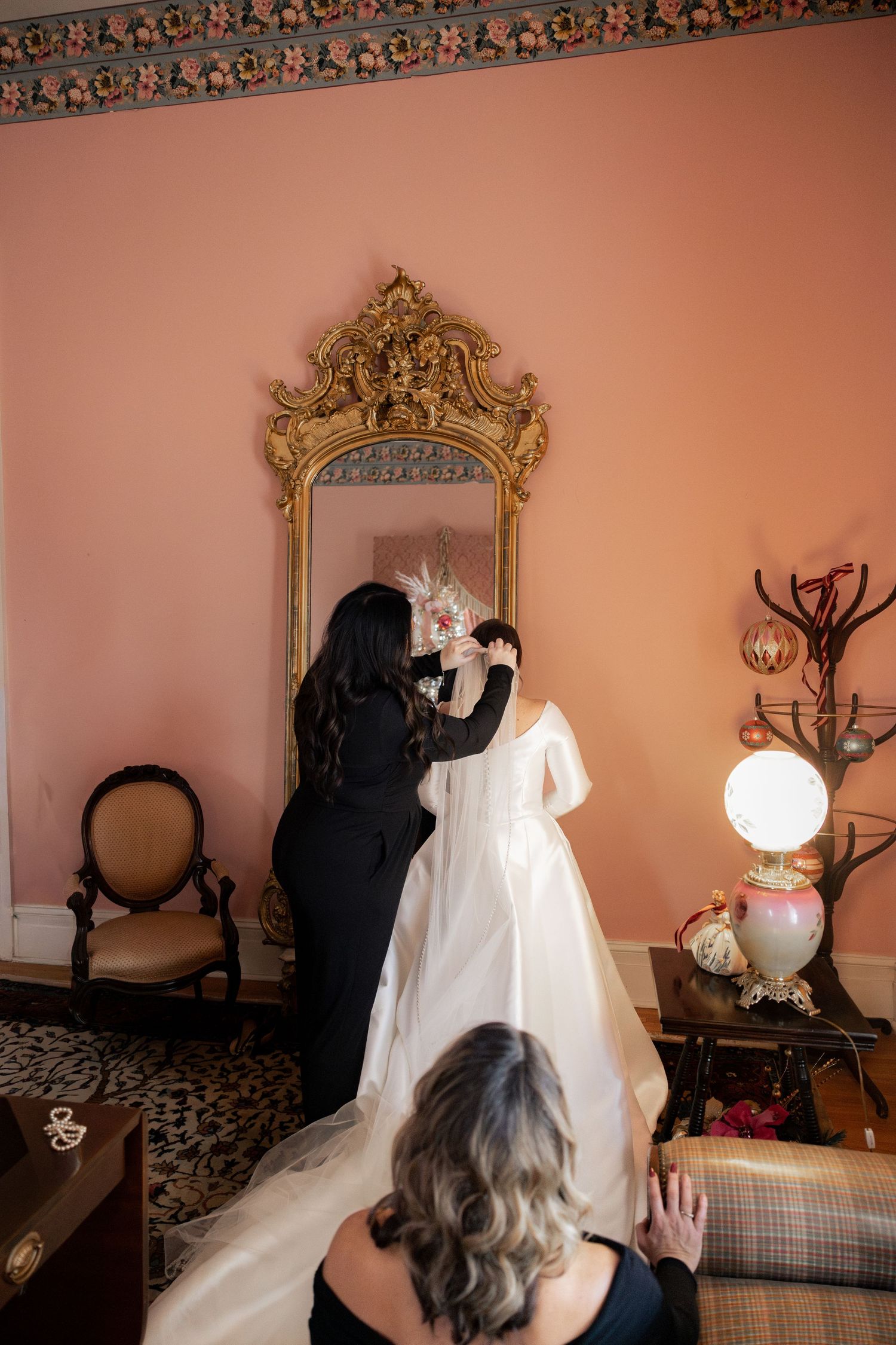 A series of photos showing someone playing with ghost decorations on a peach-colored wall with ornate mirrors and decor.