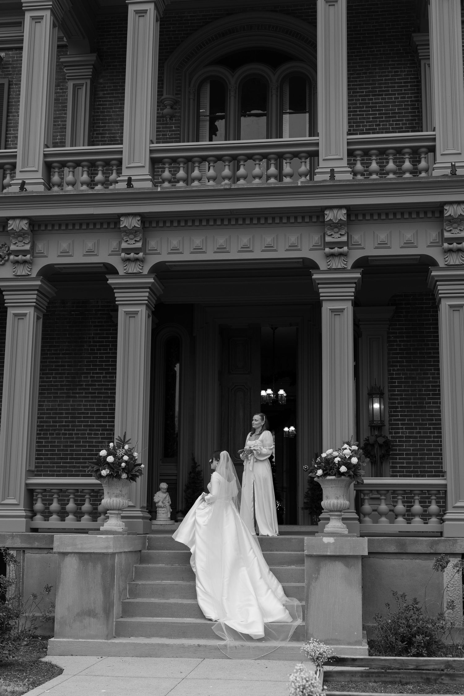 Black and white sequence showing a bride's dress flowing on historic building steps with white columns.