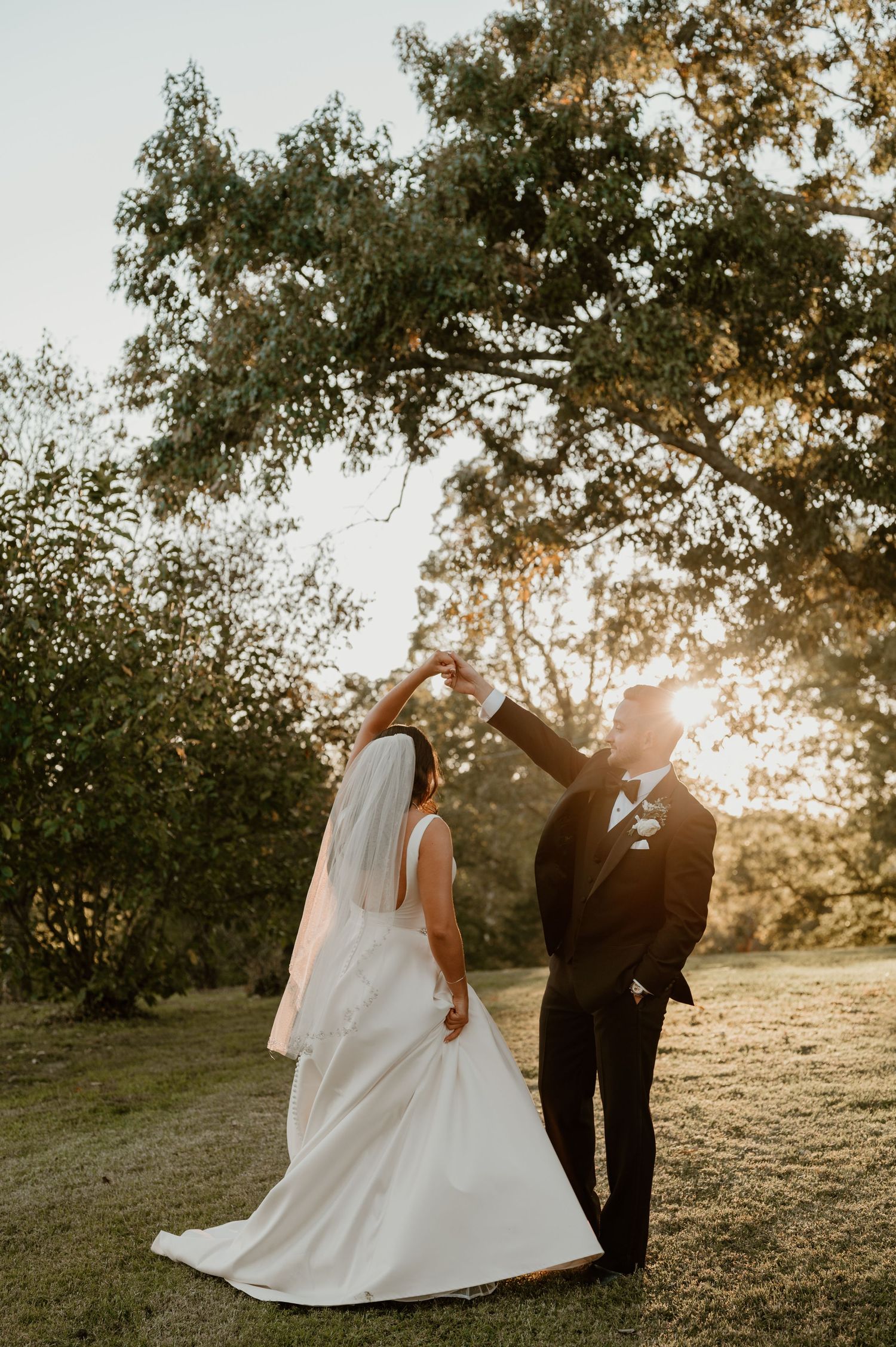 A romantic sunset wedding photoshoot with a flowing white dress in a natural outdoor setting.