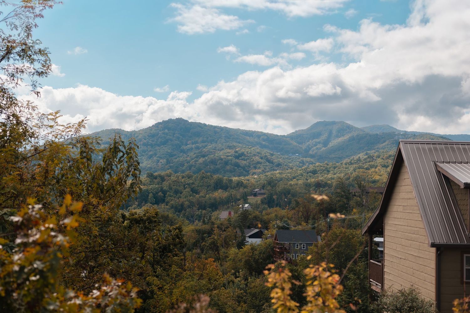 Mountain landscape with autumn foliage and blue skies in a scenic panoramic view.