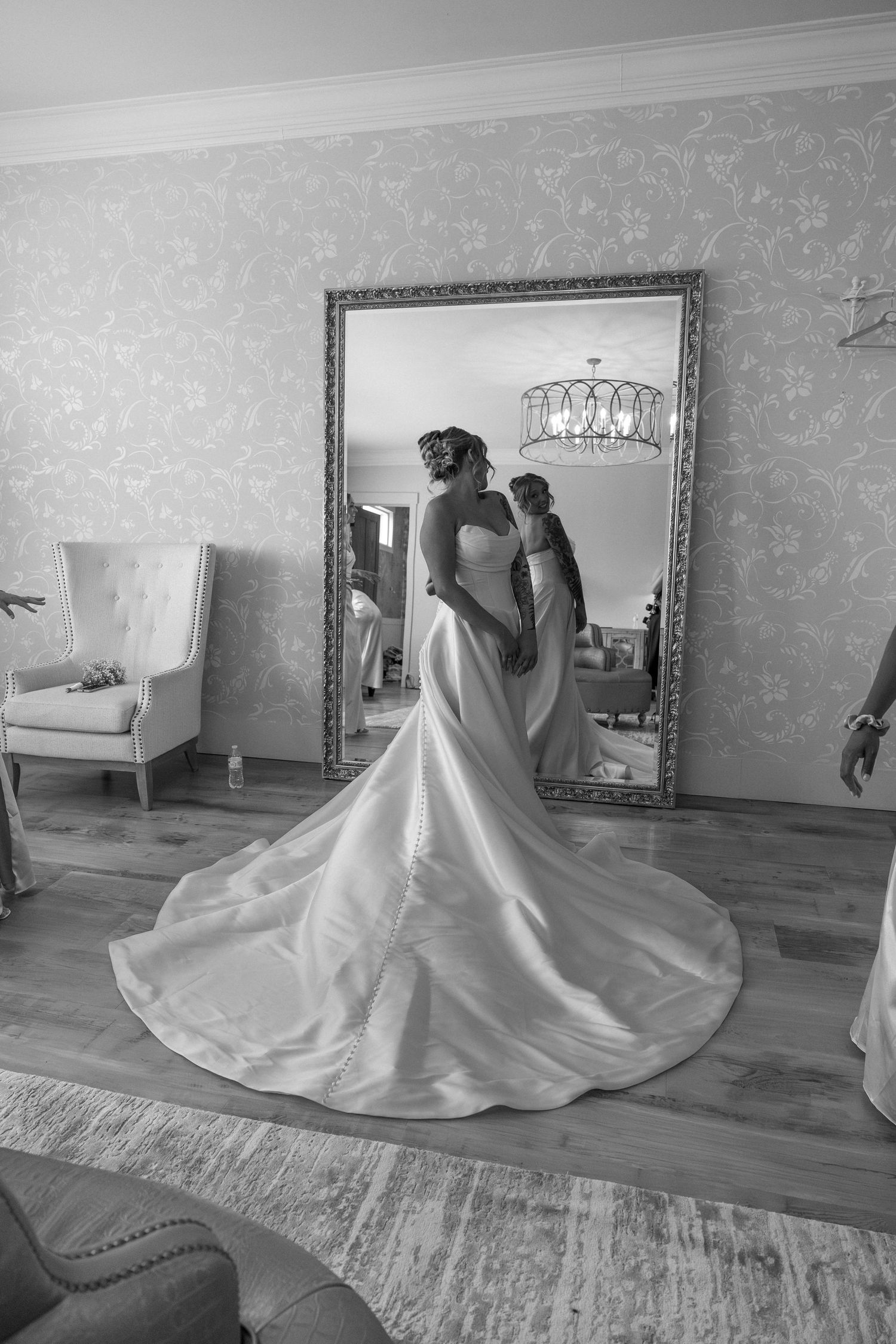 White wedding dress flowing across hardwood floor during bridal portrait session.