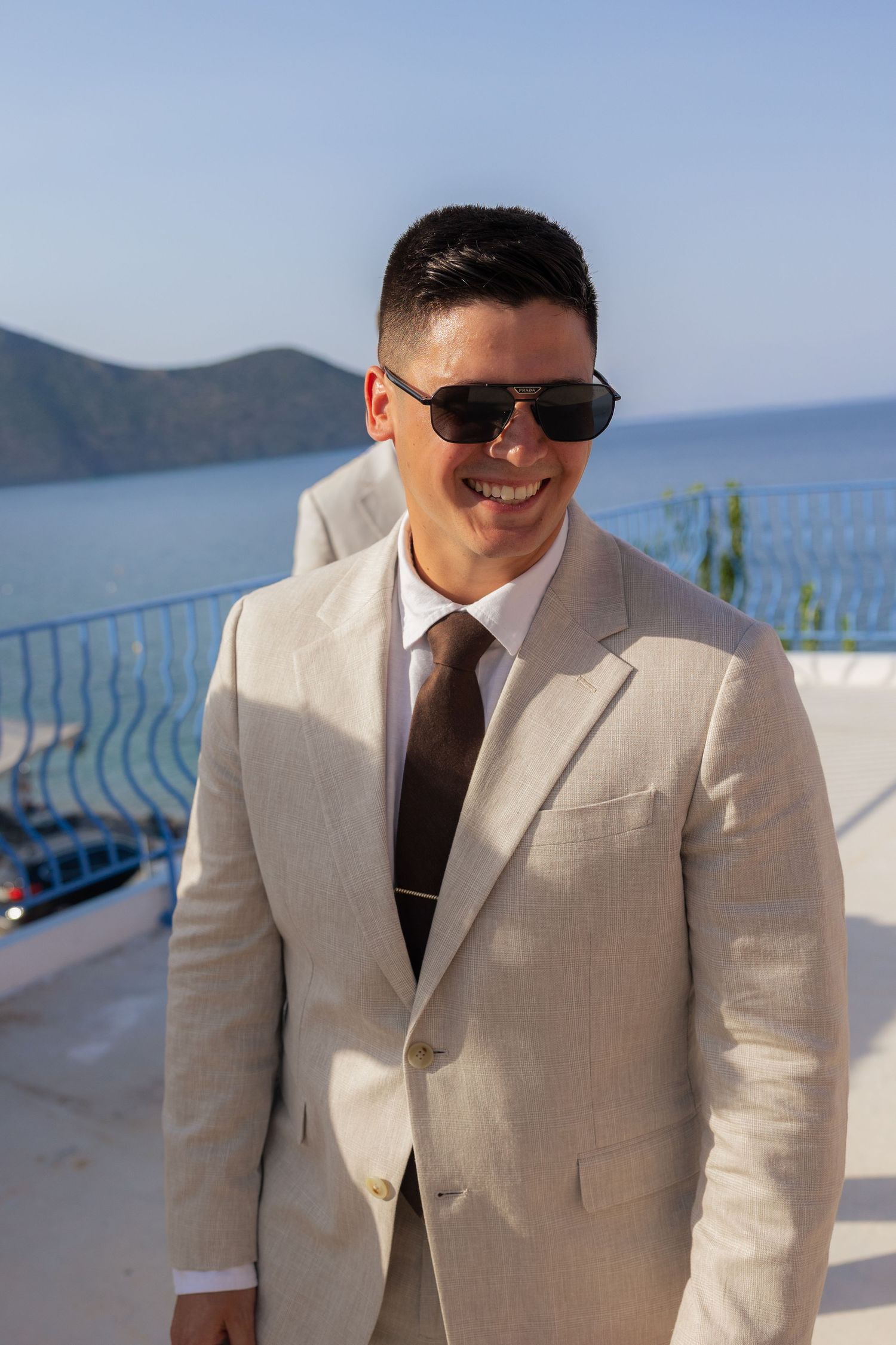 A sequence of photos showing a person in a beige suit and sunglasses posing against an ocean backdrop.