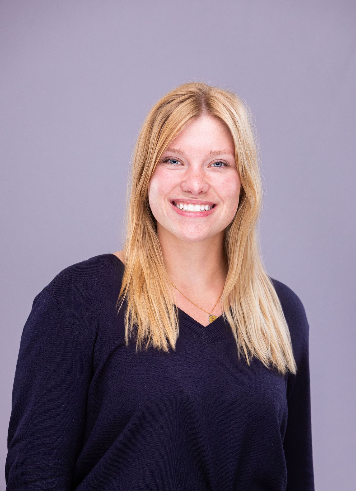 Five headshots showing various expressions of a blonde-haired figure in a black top against a purple background.