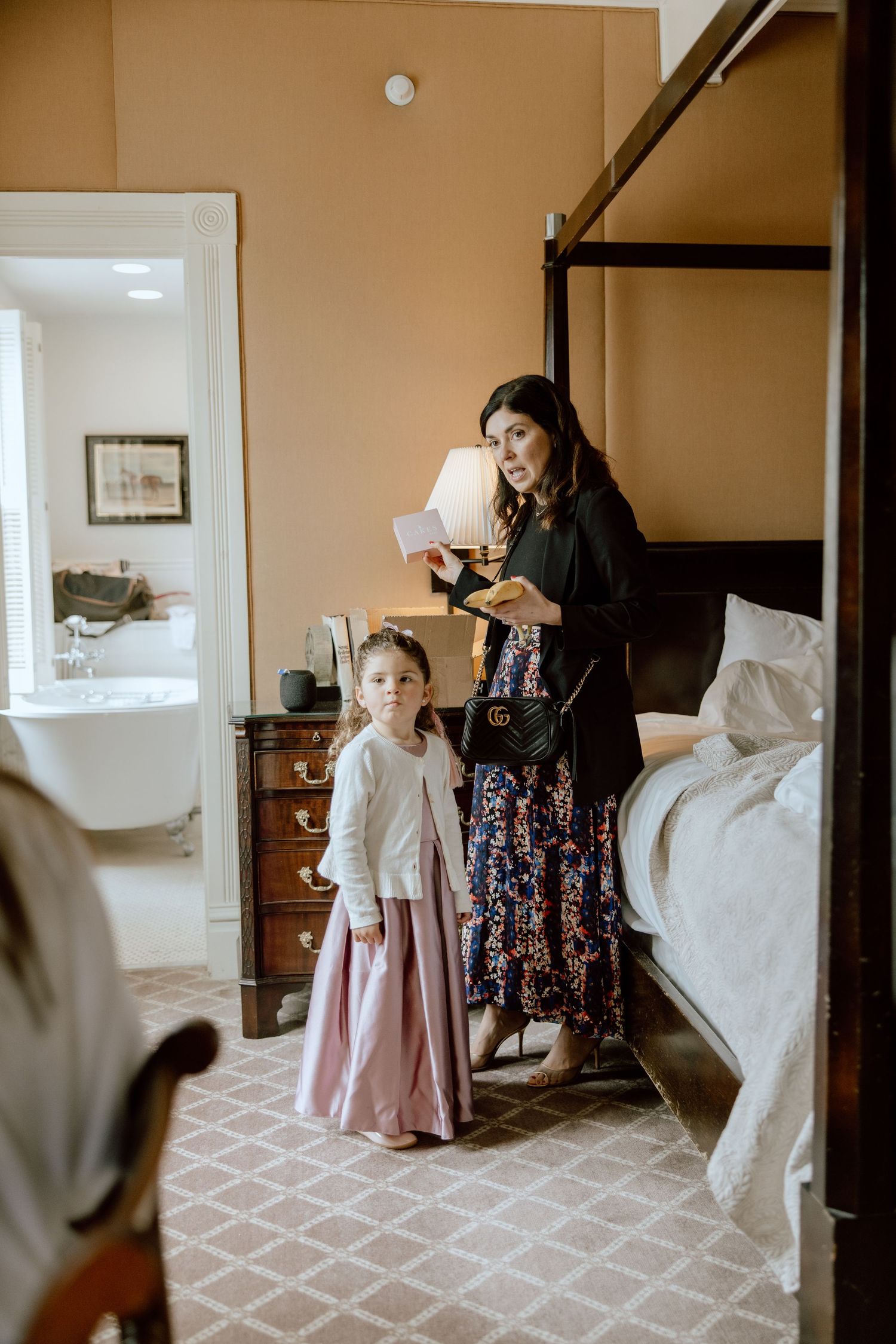 Getting ready scene in bedroom with pink dress and floral pattern.