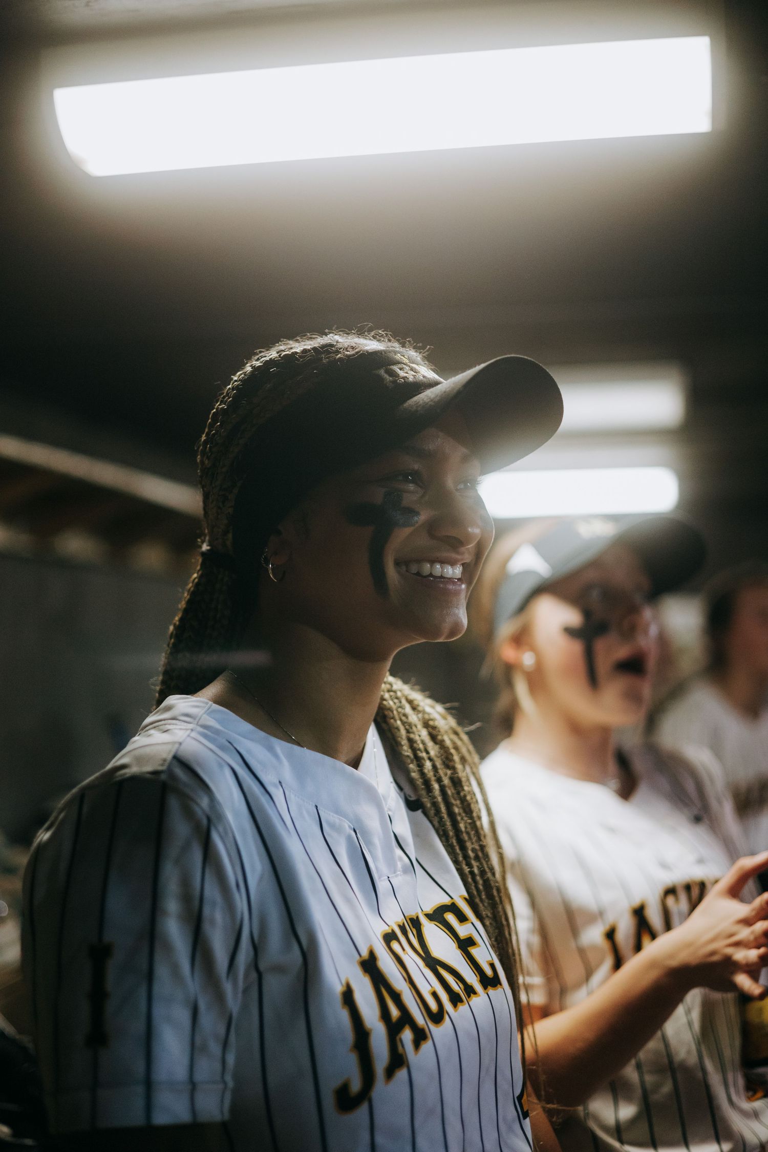Irmo HS Teammates share joyful moment in dugout wearing baseball jerseys.