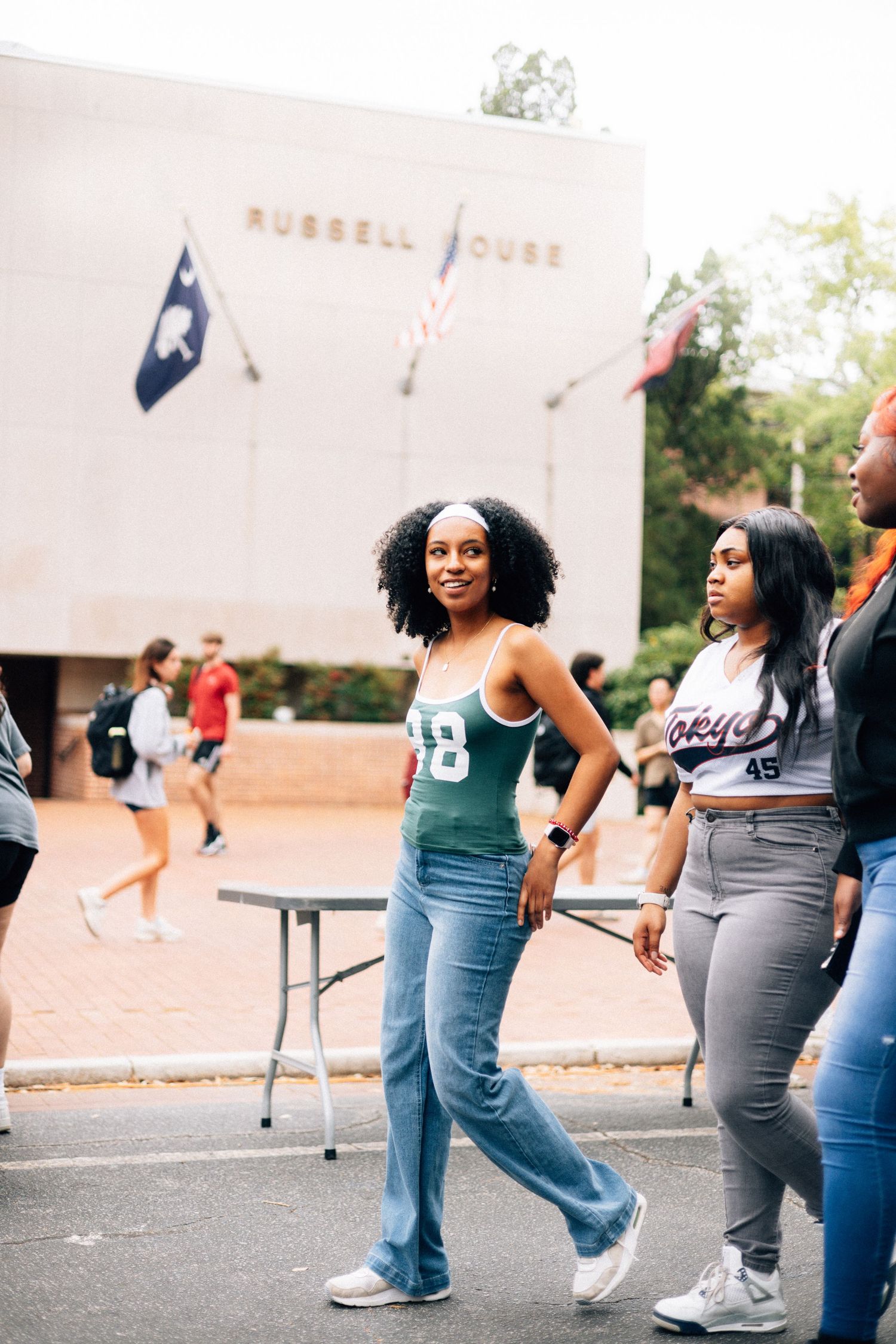 Students gathered outside a campus building in casual wear enjoying social activities at a university.