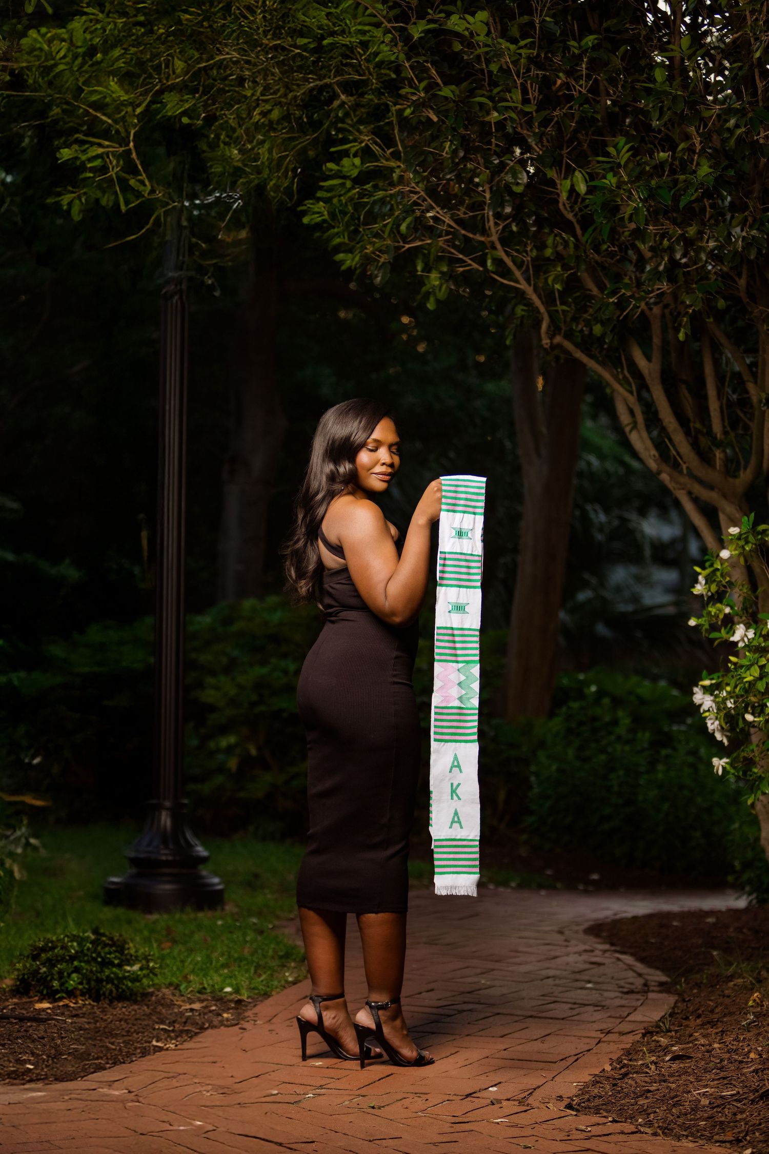 Evening graduation portrait session on brick pathway.