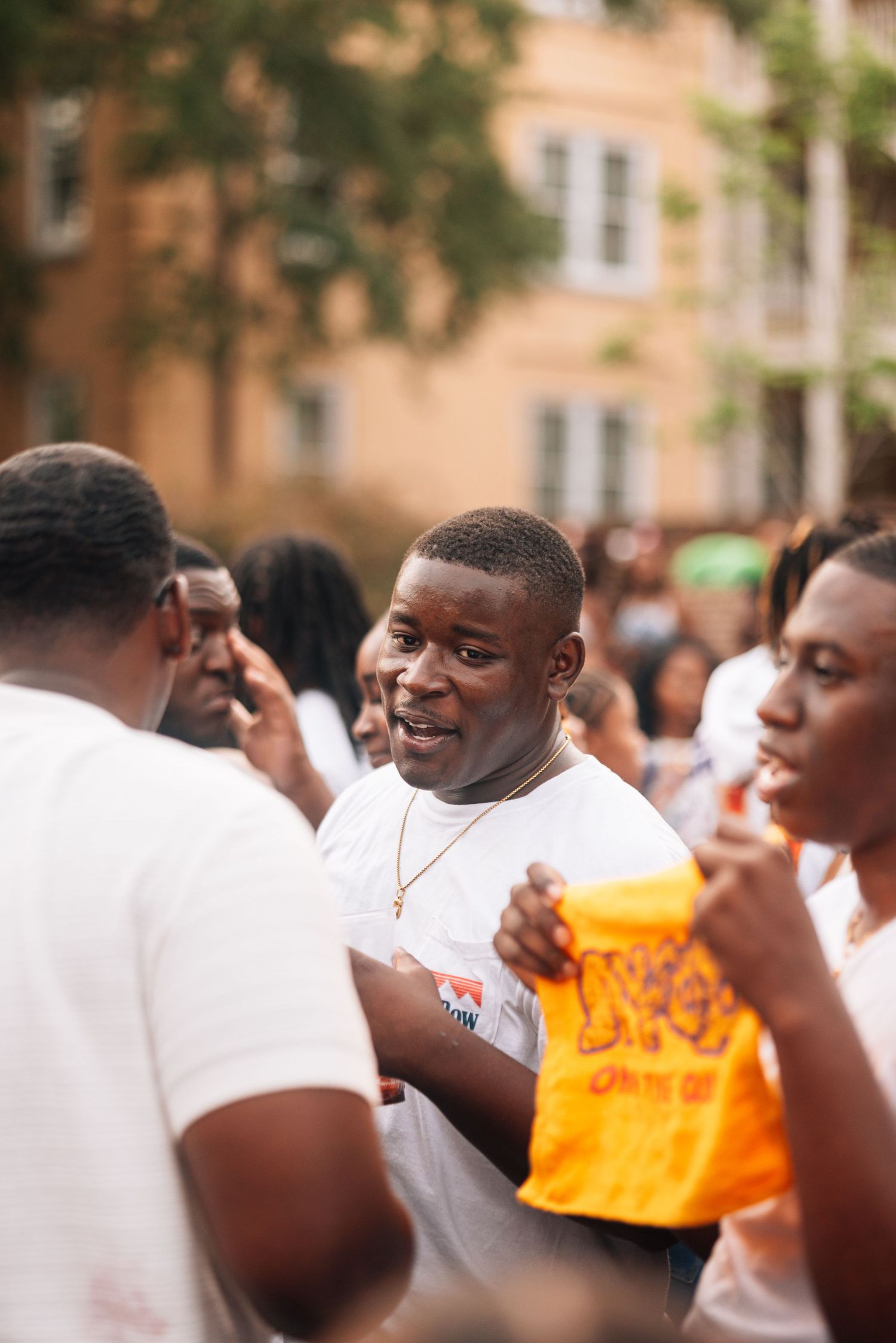 Two people in white shirts engaged in an outdoor social gathering.