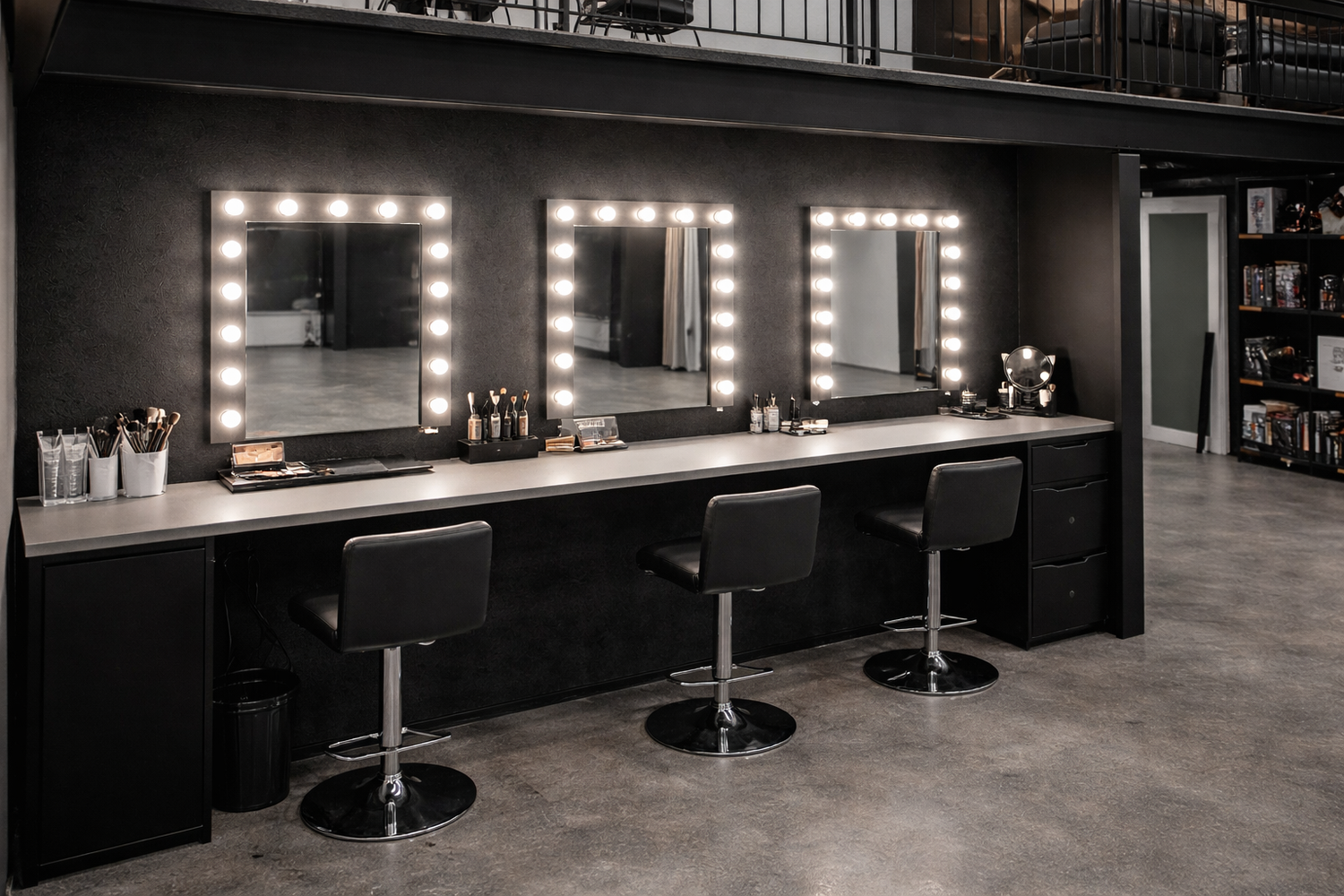 Modern dressing room interior with illuminated mirrors and black styling stations.