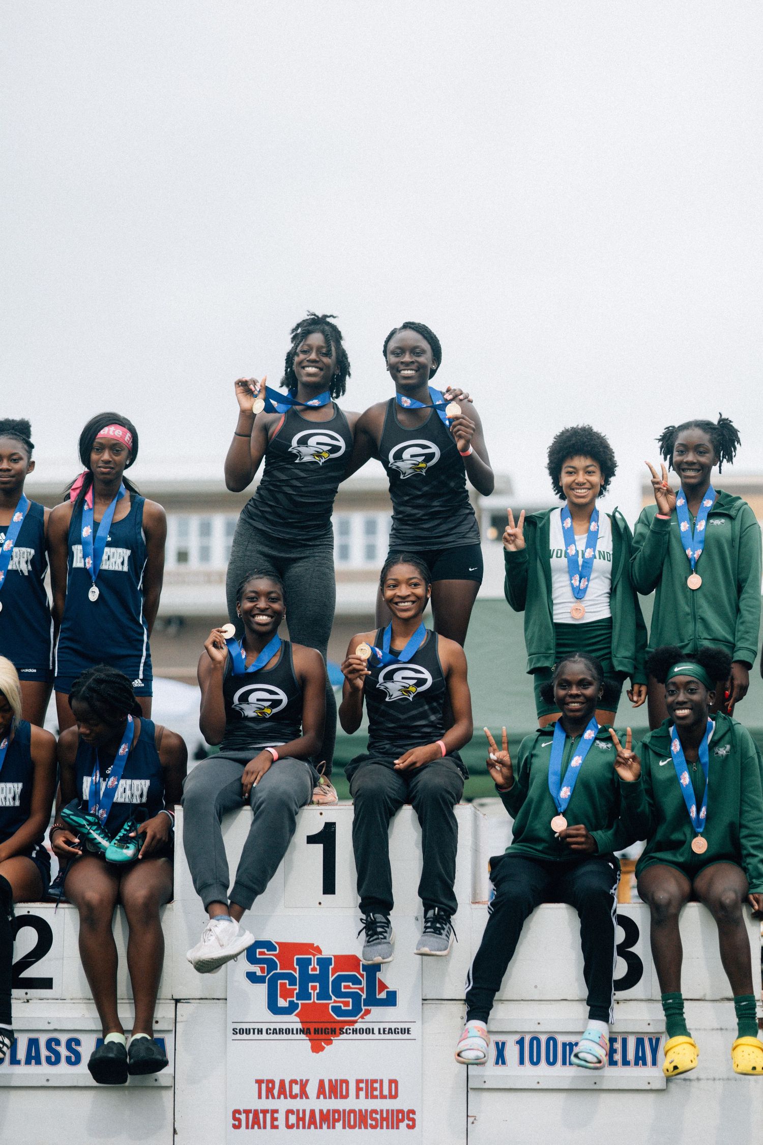 Track team members celebrating with medals at state championships.