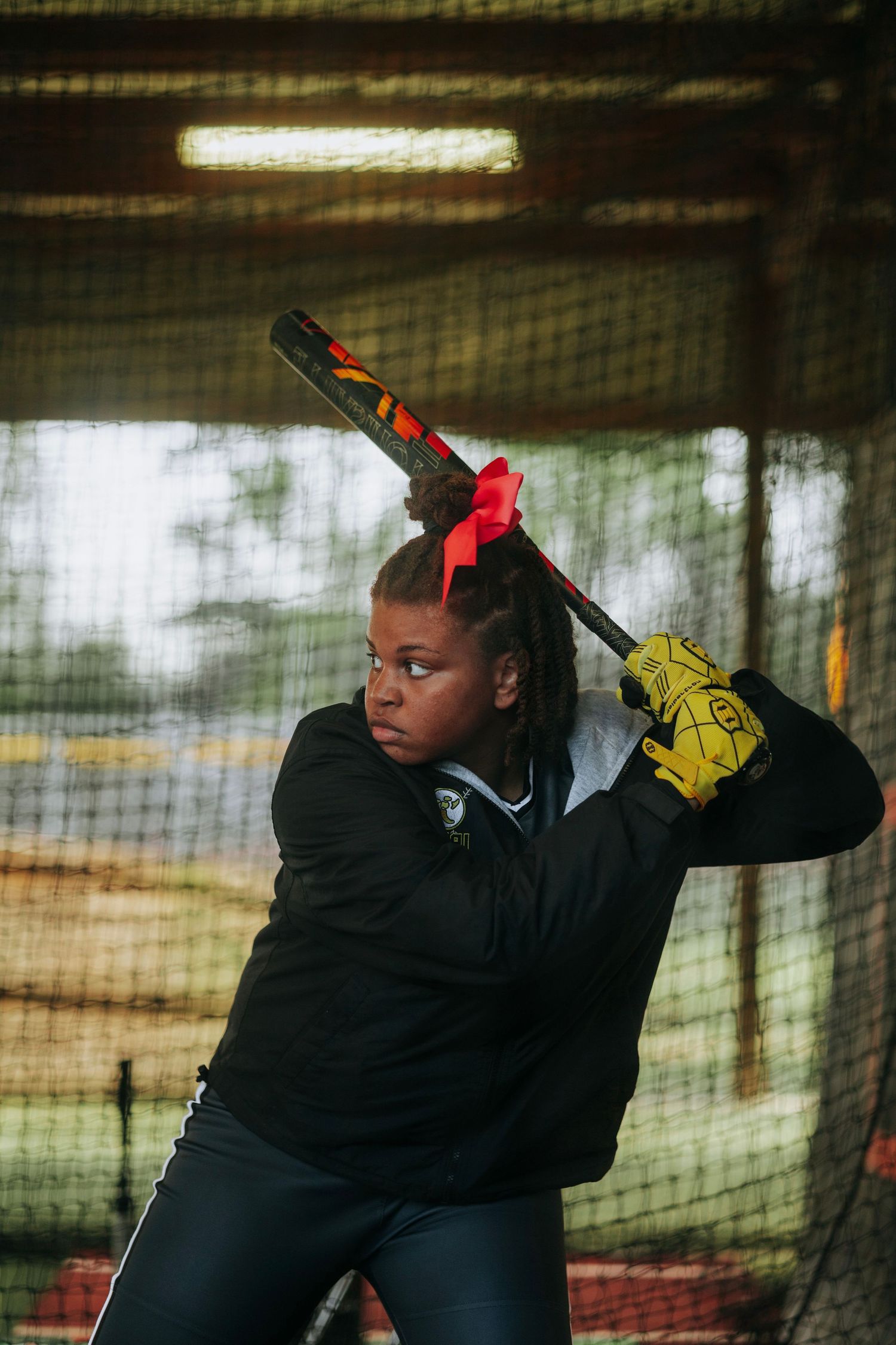 Irmo HS Softball player practices batting stance in indoor facility.