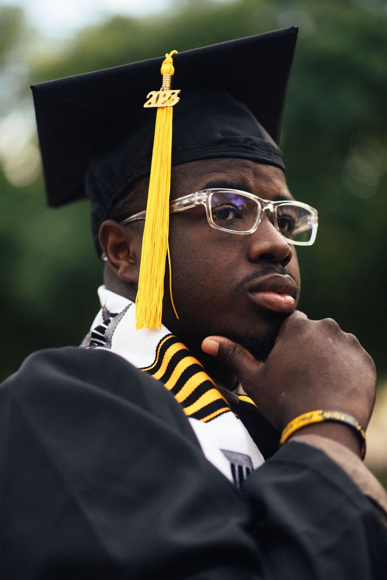 A sequence of graduation photos showing side profile angles with black caps and yellow tassels.
