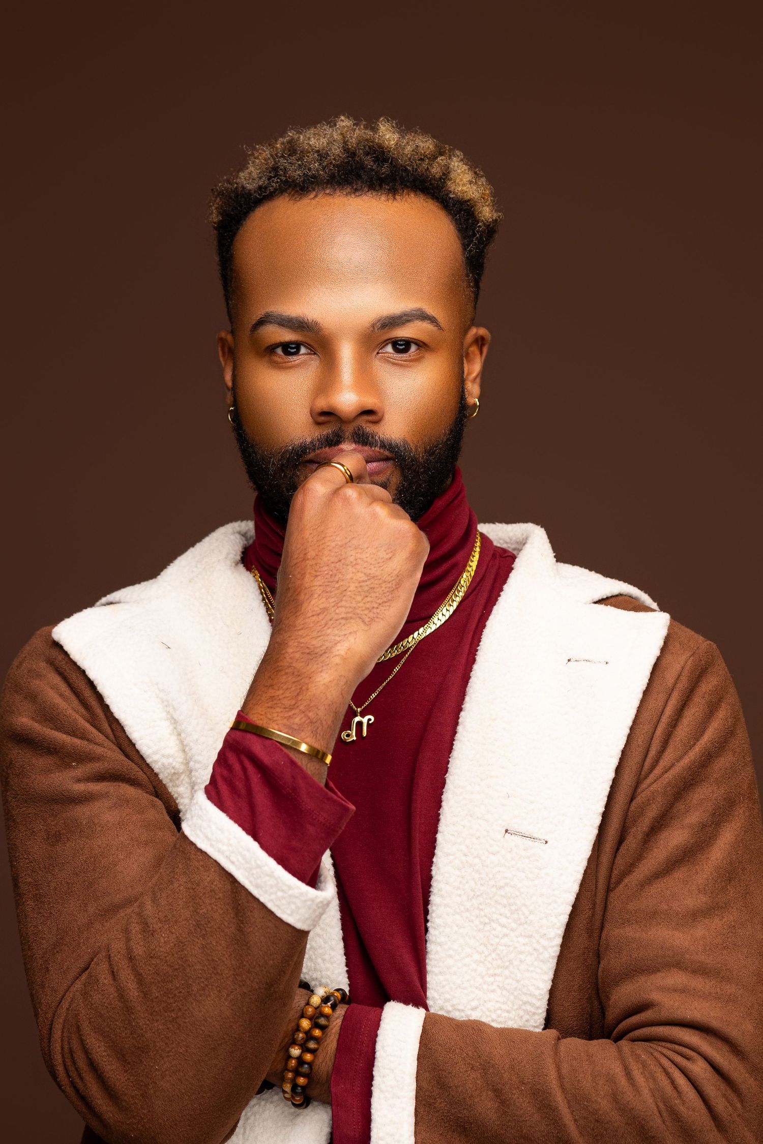 Portrait photo series showing various poses against brown background wearing brown and burgundy clothing.