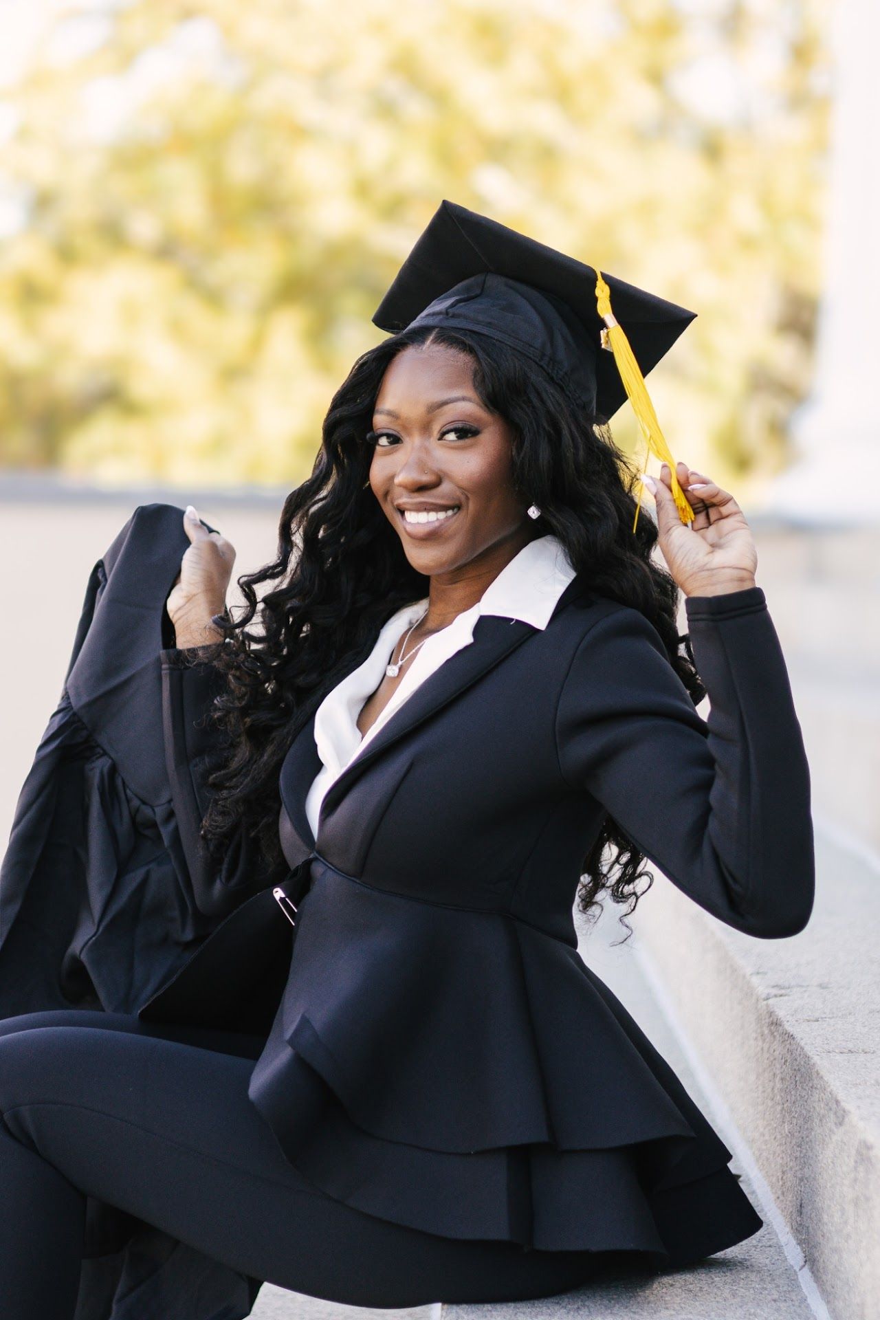 A graduating student in academic regalia poses playfully in a series of celebratory shots against a light background.