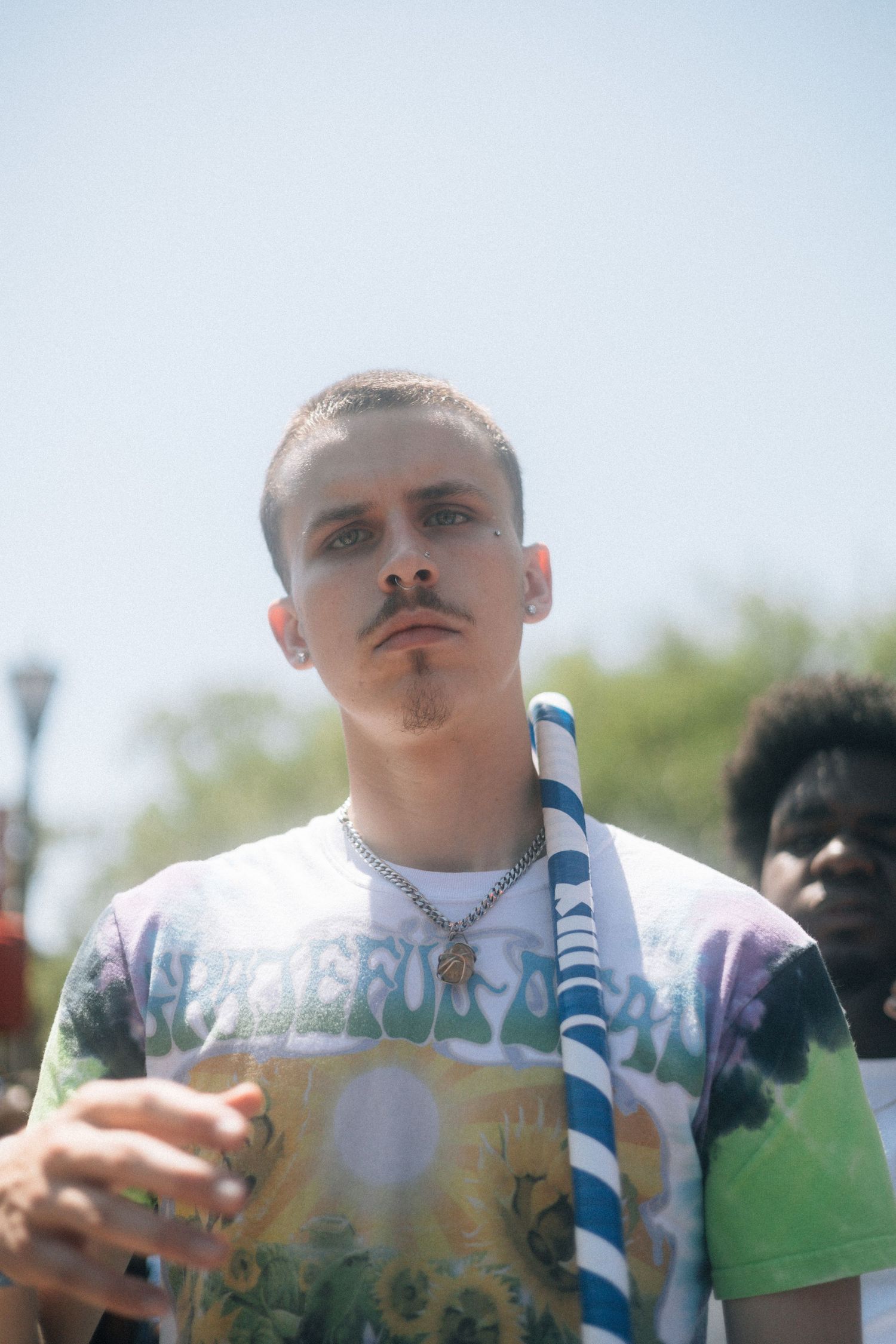 A person taking a drink from a blue-striped straw while looking towards the camera. USC Hip Hop Wednesday