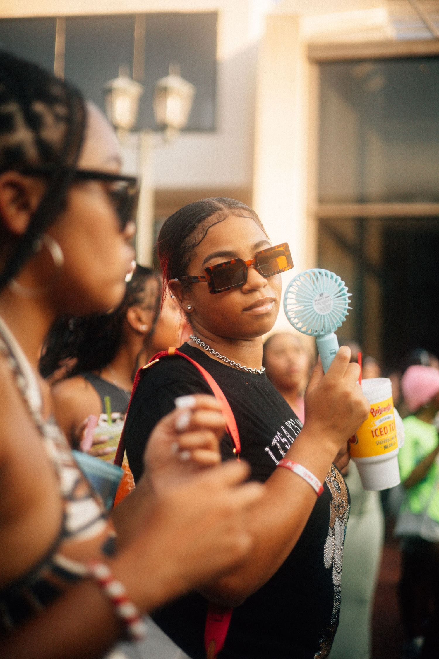 Person in sunglasses blowing bubbles at a party while others gather in the background.  USC Hip Hop Wednesday