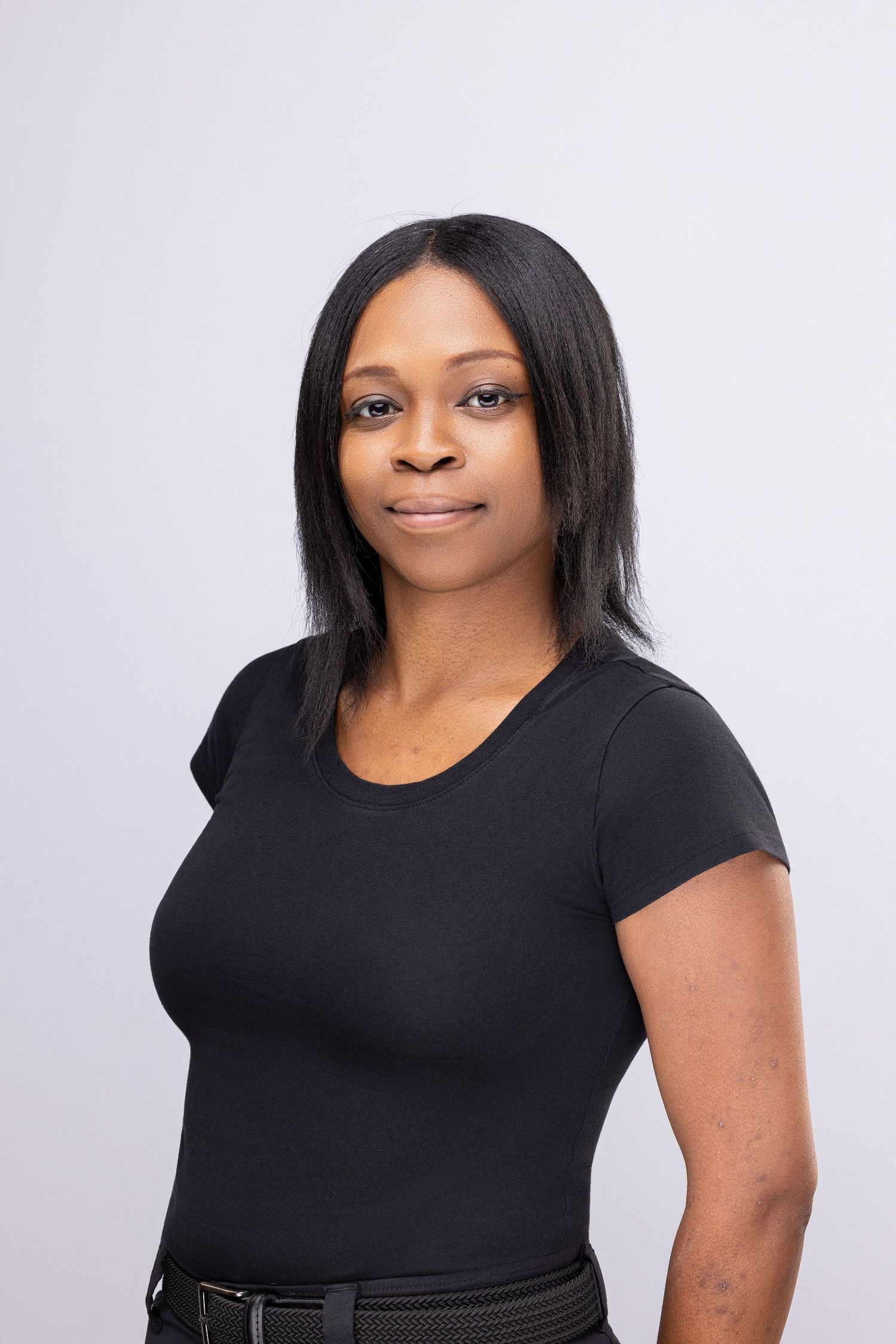 Professional studio portrait of a person wearing a black t-shirt against a light gray background.