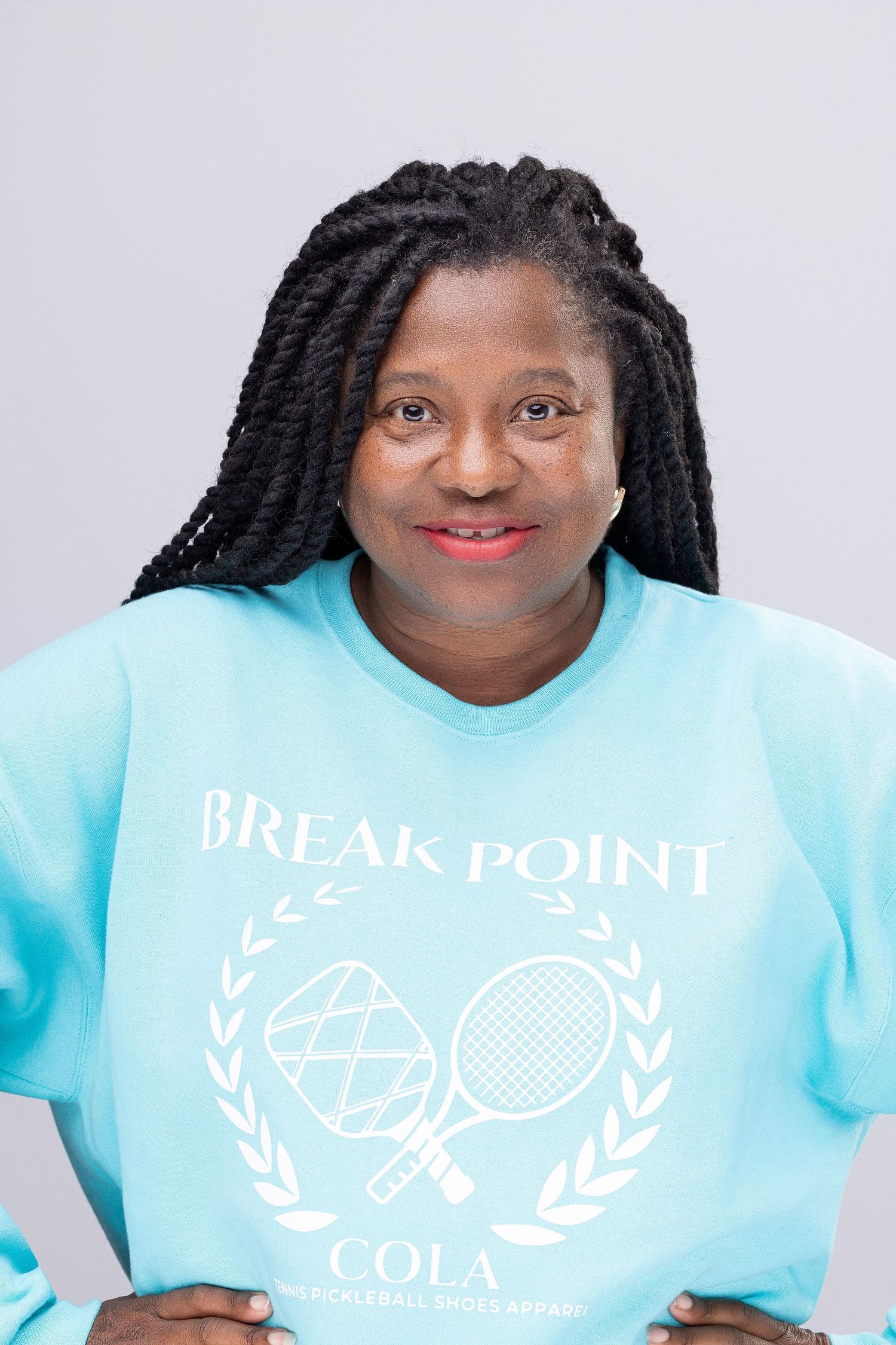 Person wearing light blue t-shirt with Break Point Cola logo and text against white background.