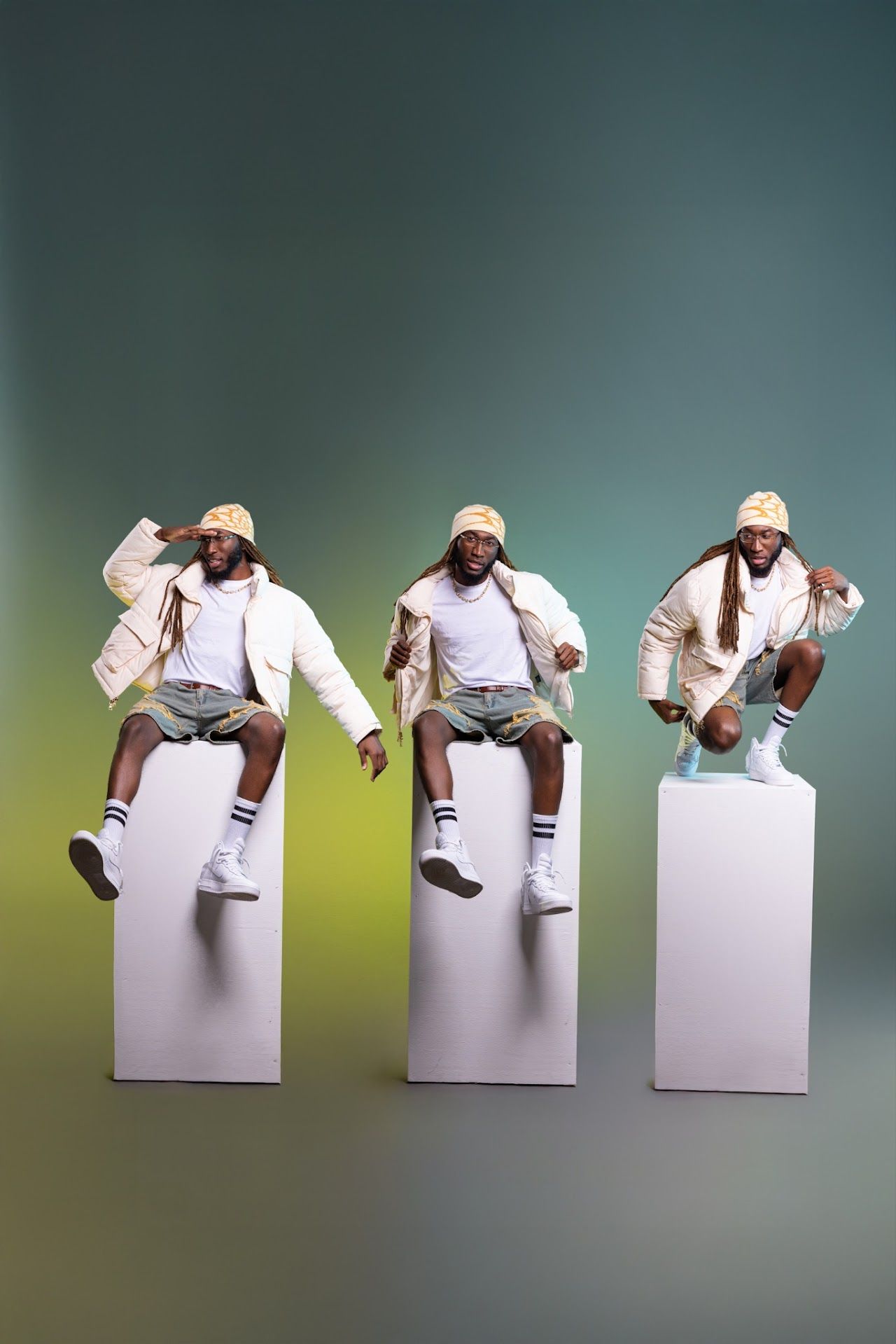 Three identical artistic poses of a performer in white sitting on blocks against a gradient background.