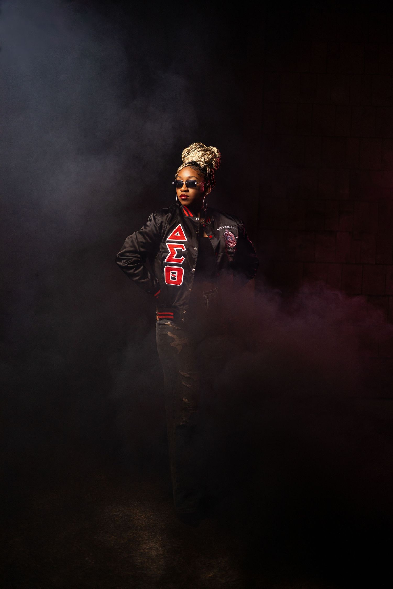 Artistic portrait with smoke effects and Greek letter details in dark lighting.