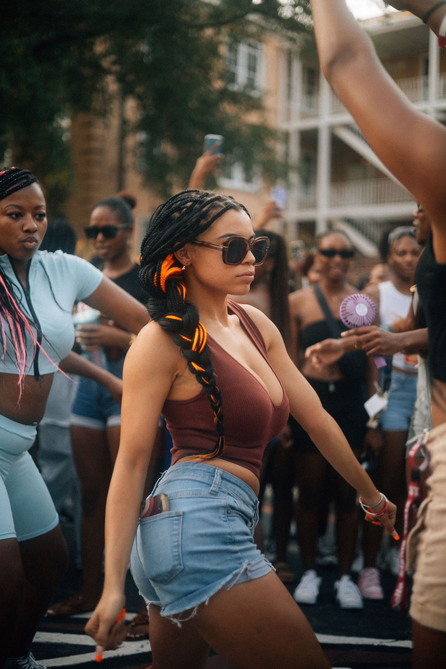People dancing and enjoying a lively outdoor street party or festival on a sunny day wearing casual summer attire.  USC Hip Hop Wednesday