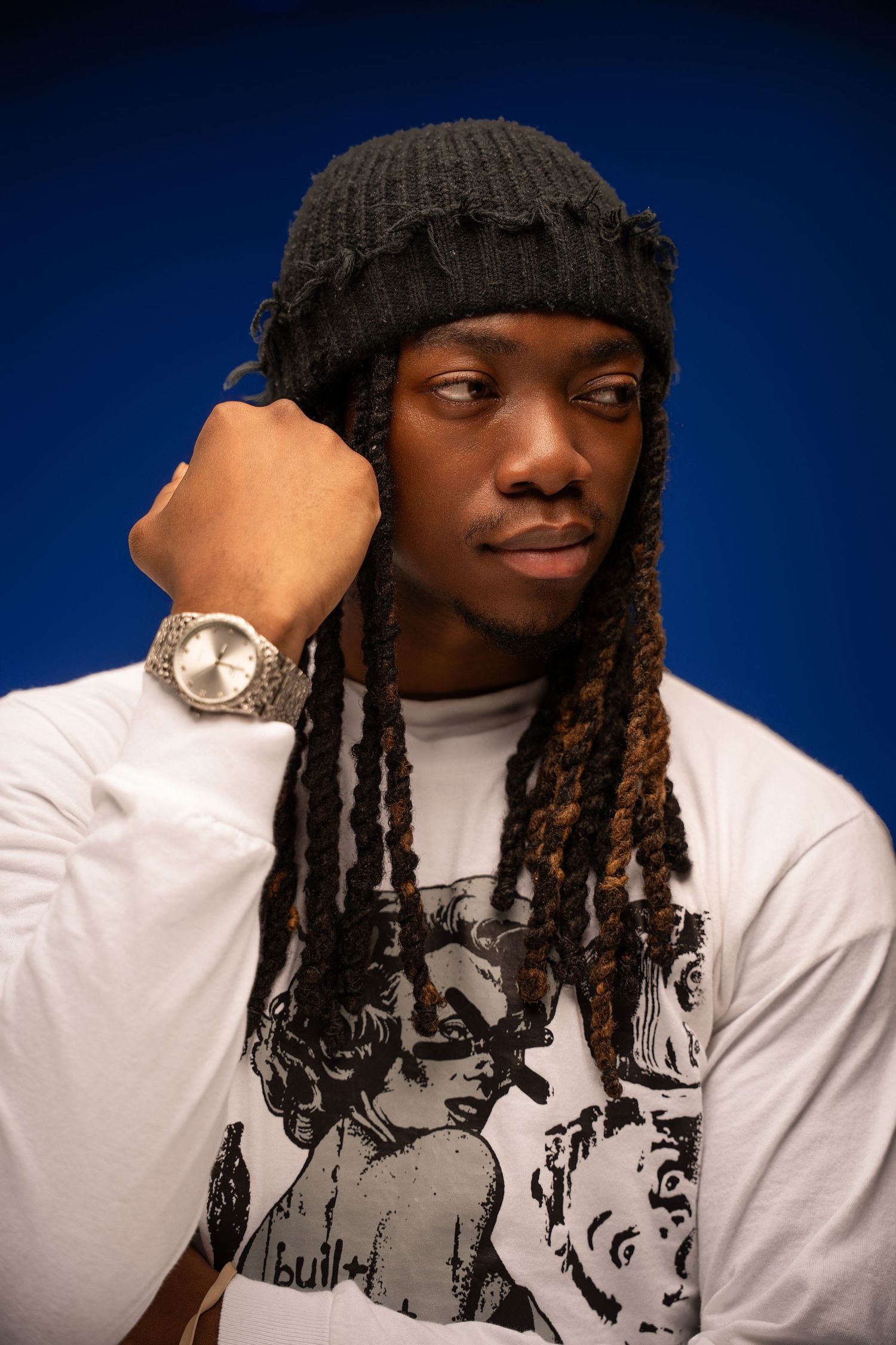 A series of artistic portrait photos showing someone in a white sweater and black beanie against a dark blue background.