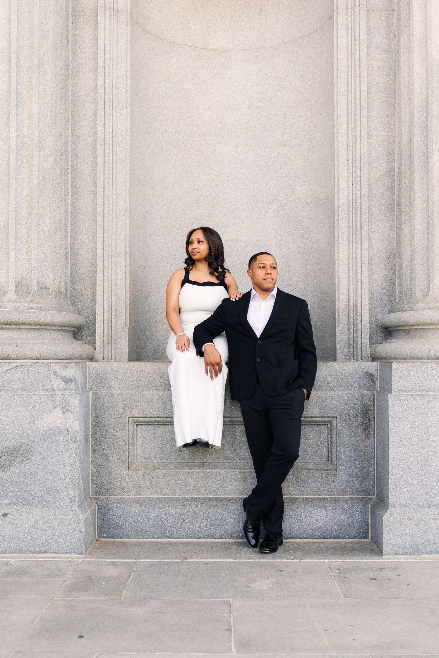 A creative wedding photo series showing a couple posing playfully against a white stone wall with columns.