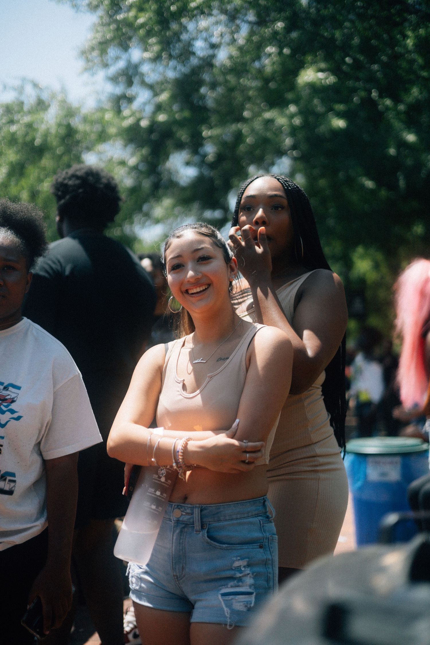 Group of friends laughing and enjoying a sunny outdoor gathering in casual summer outfits. USC Hip Hop Wednesday