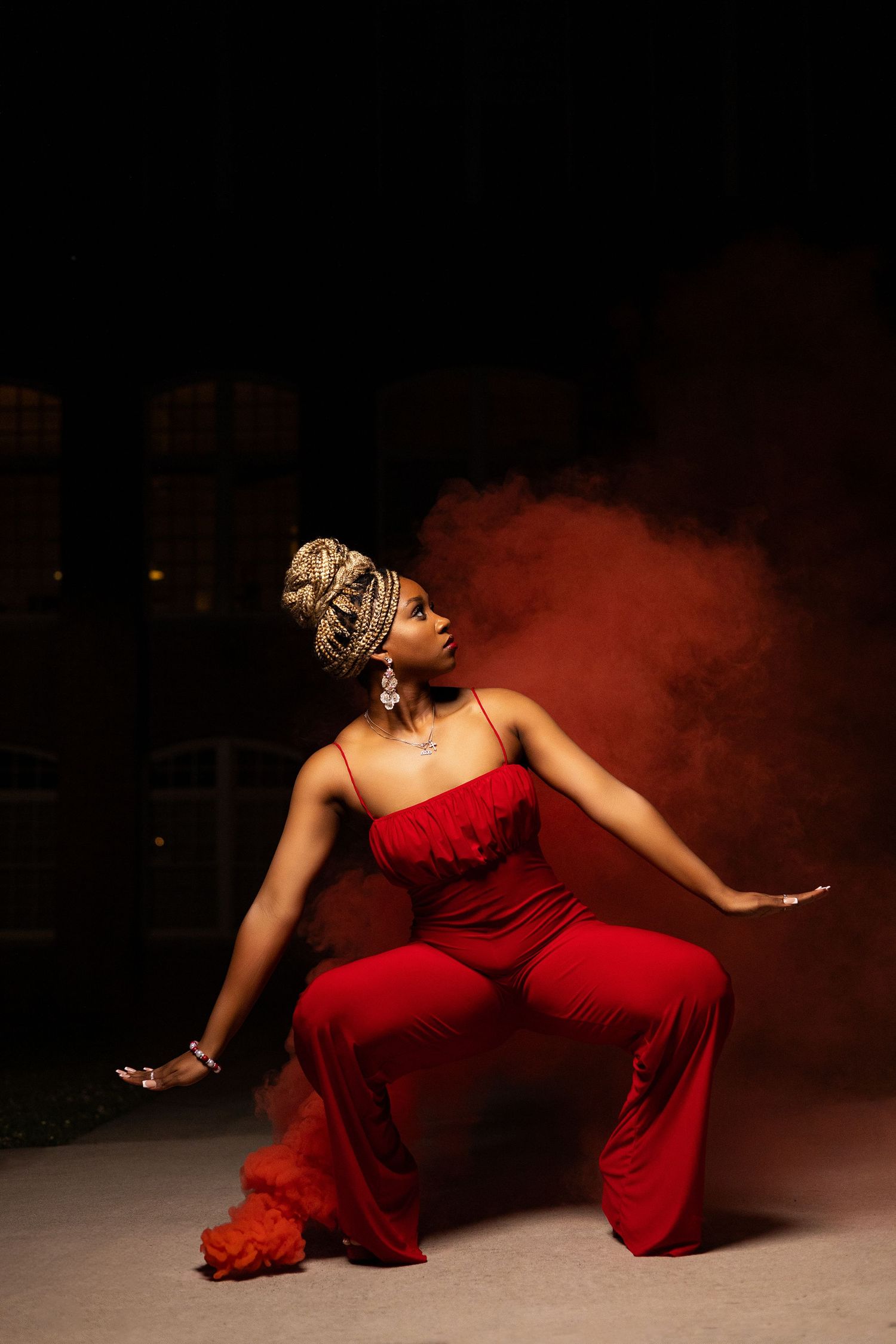 Dynamic dance poses in a red dress against a dark background with atmospheric smoke effects.